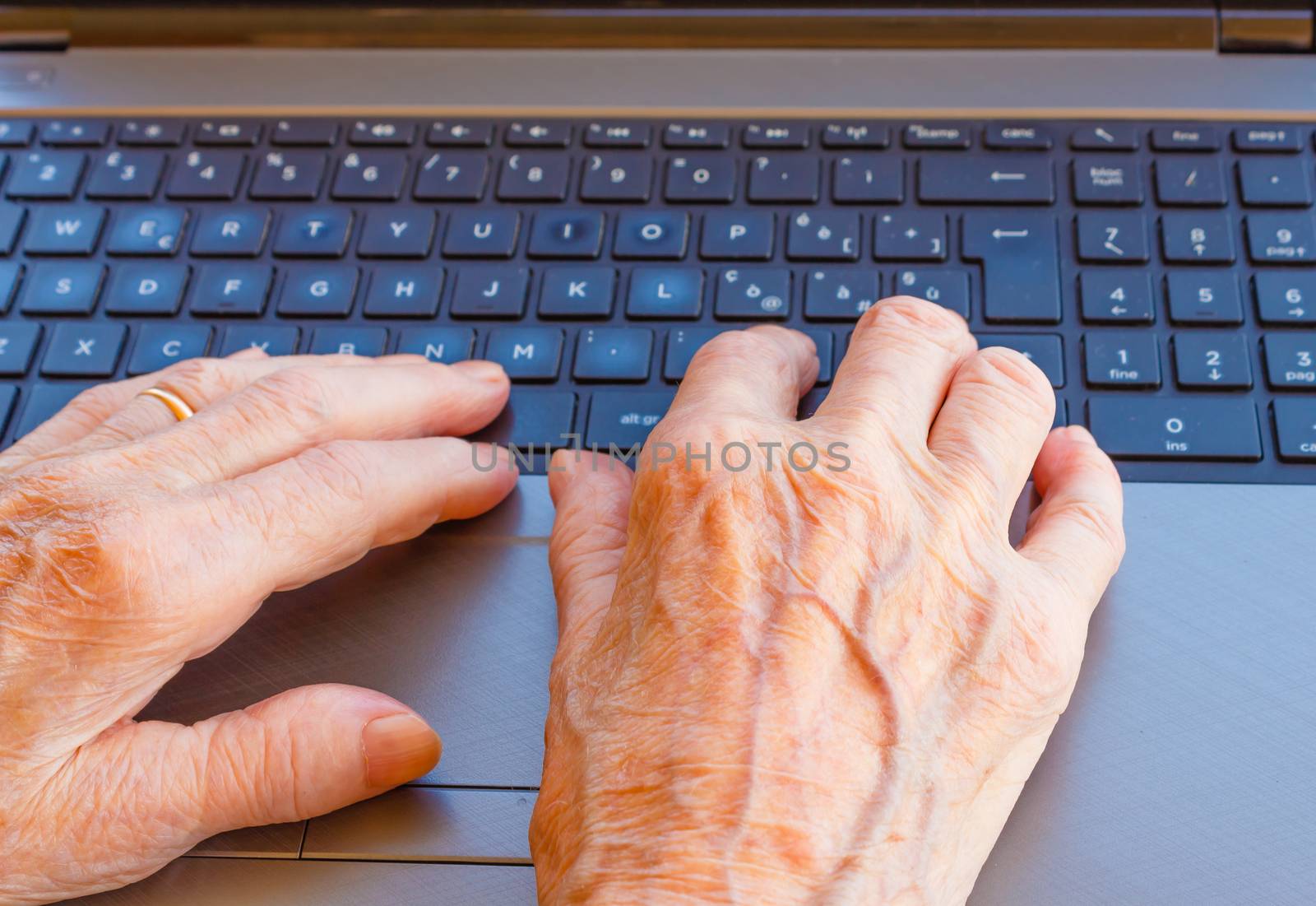 an elderly lady works at the computer by grancanaria