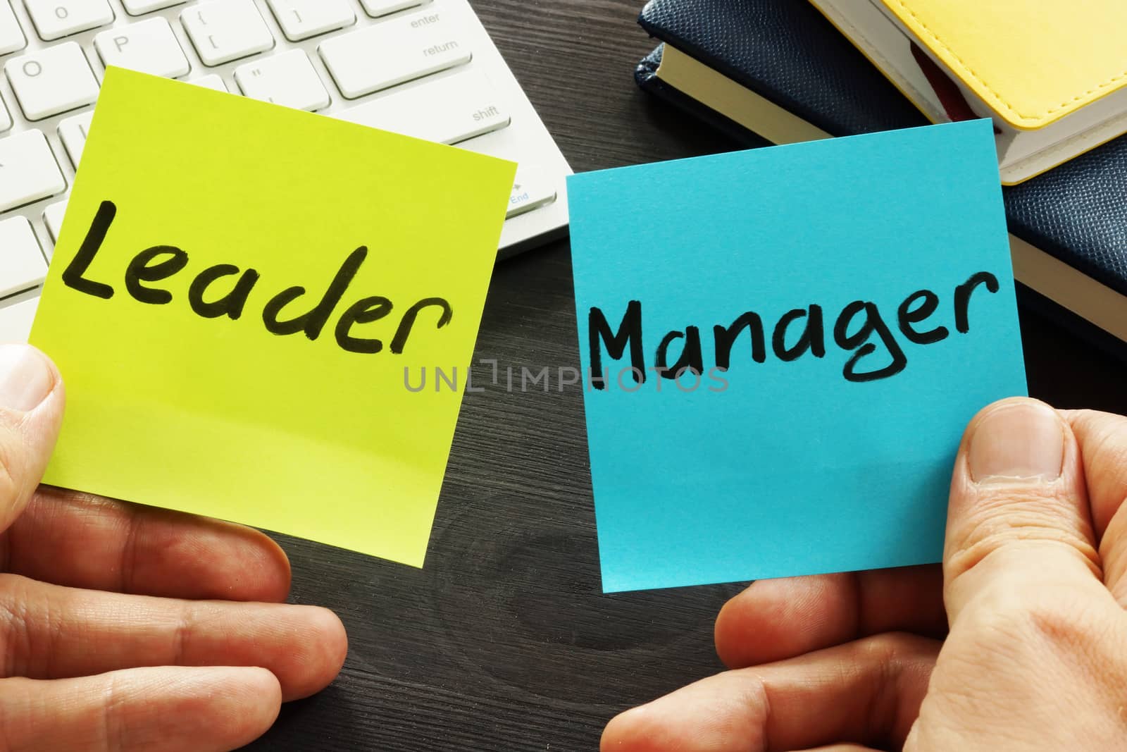Leader vs manager. Man is holding memo sticks.