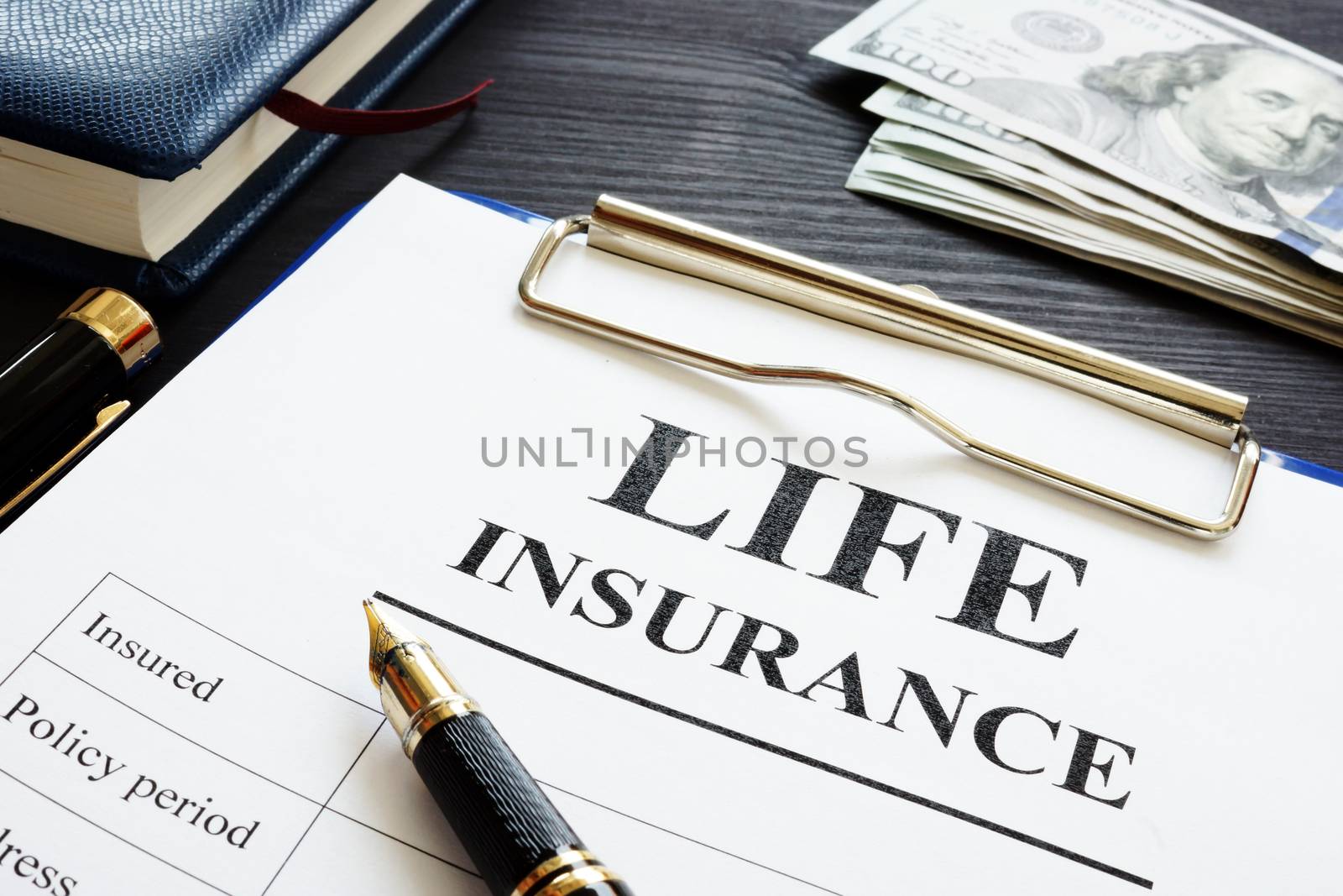 Whole life insurance pen and dollar banknotes.