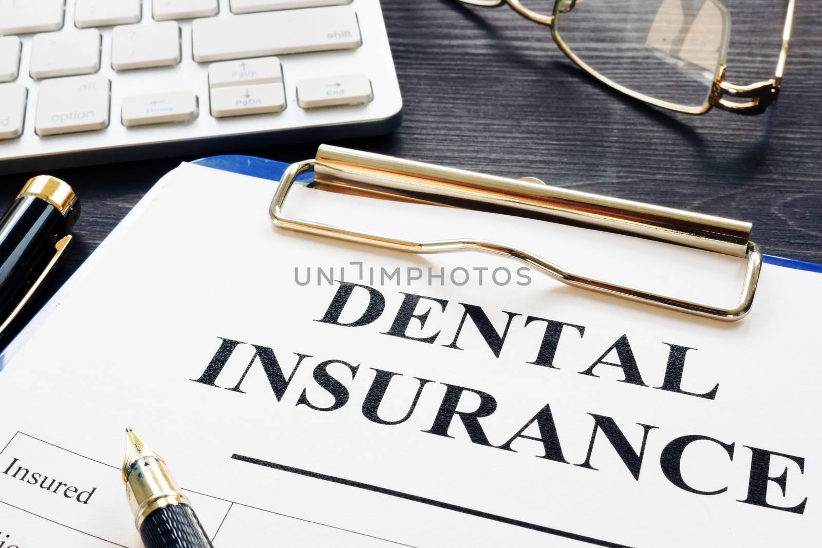 Dental insurance form and pen on a desk. by designer491