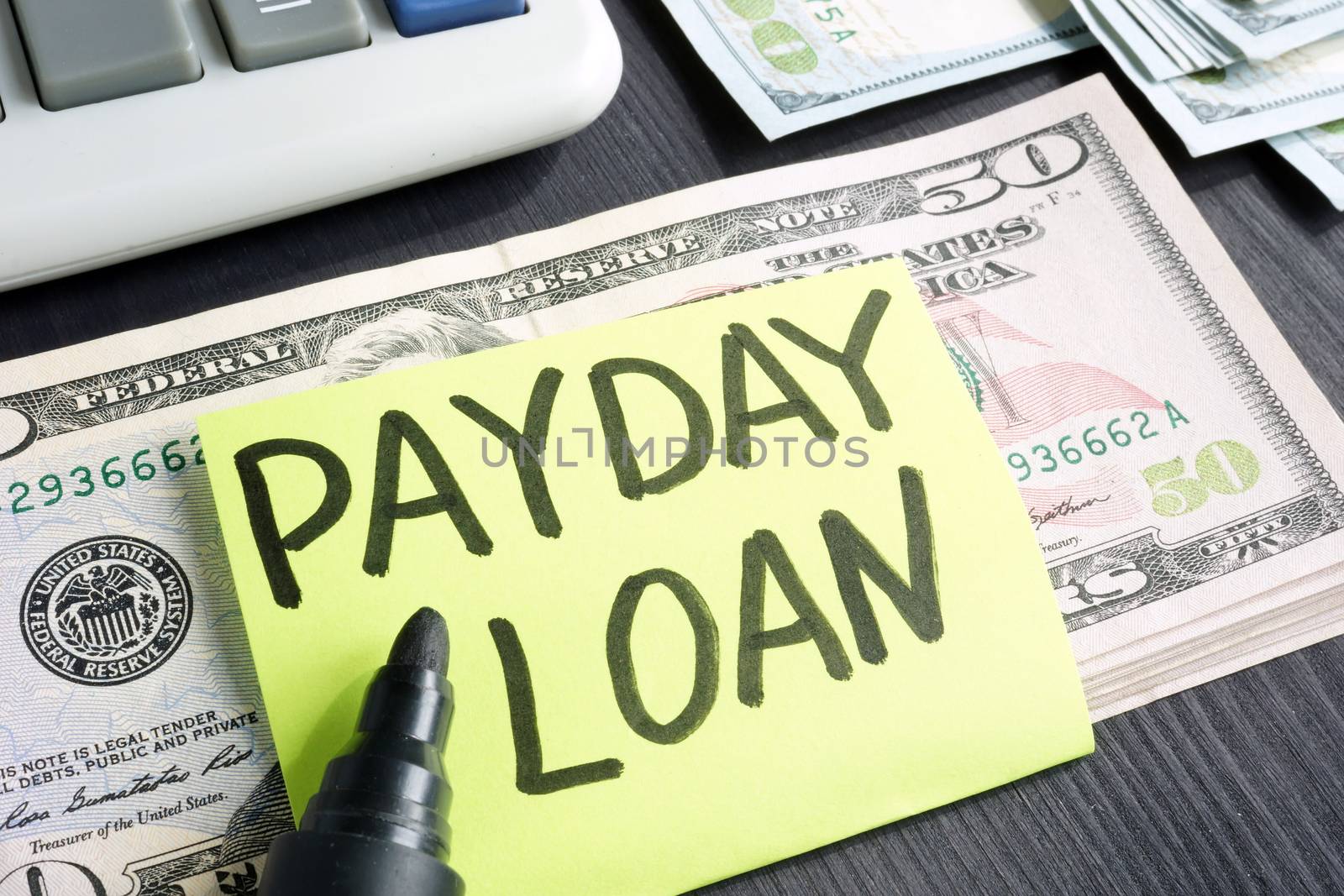 Payday loans concept. Dollar banknotes and calculator.