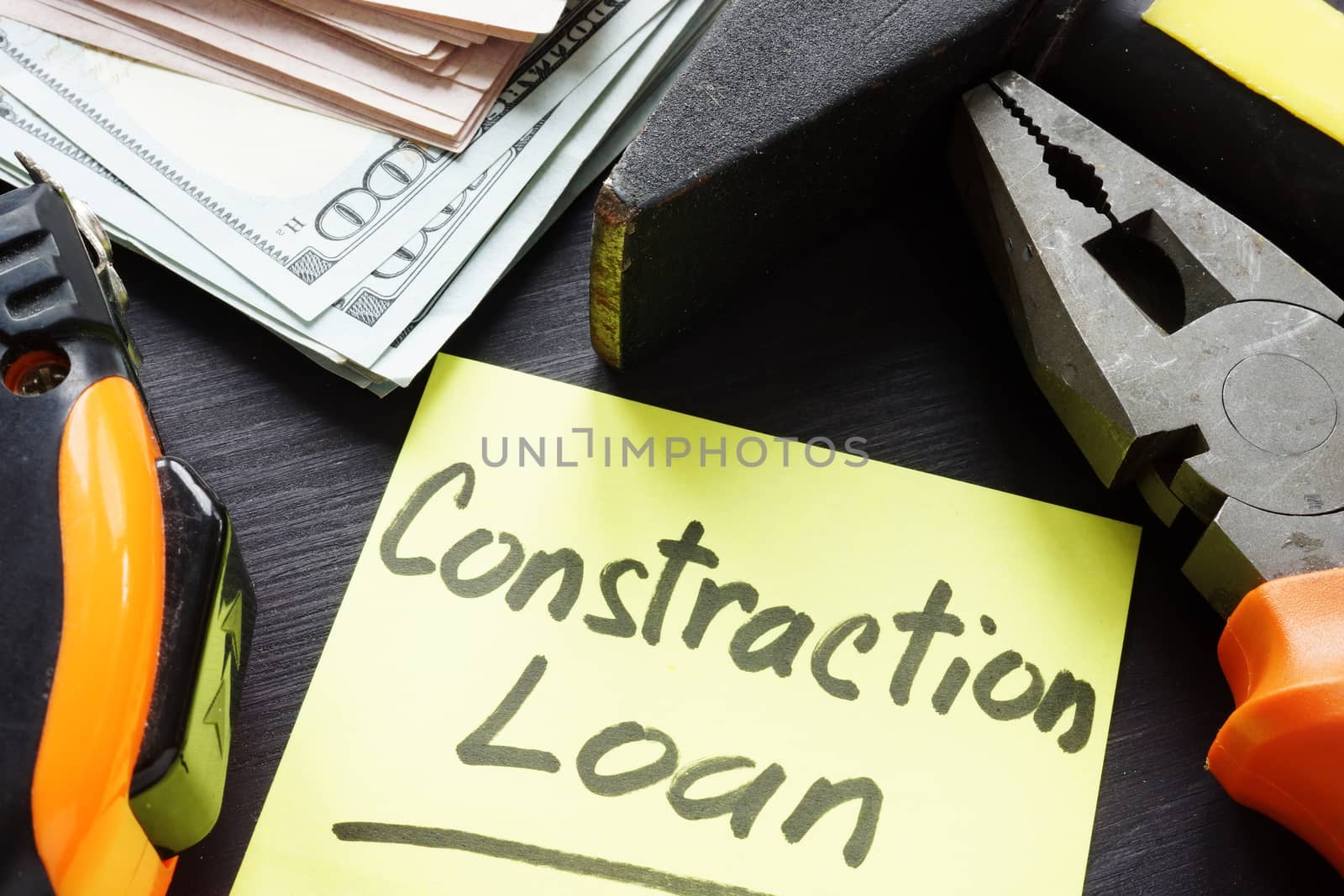 Construction loan concept. Memo stick, cash and tools.