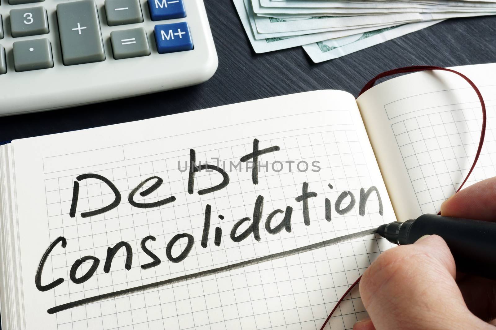 Man is writing debt consolidation in the note.