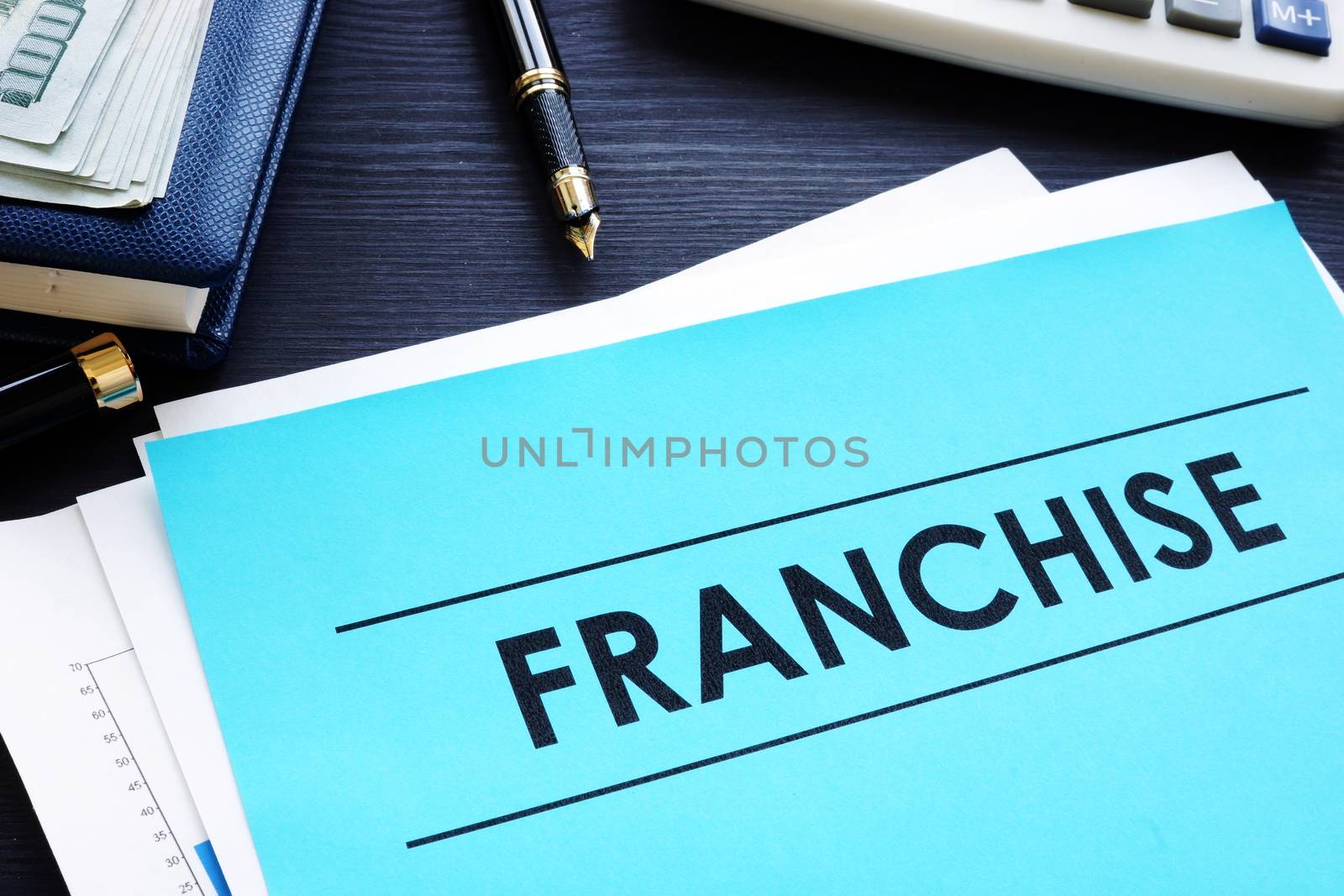 Documents with title franchise on a desk. by designer491