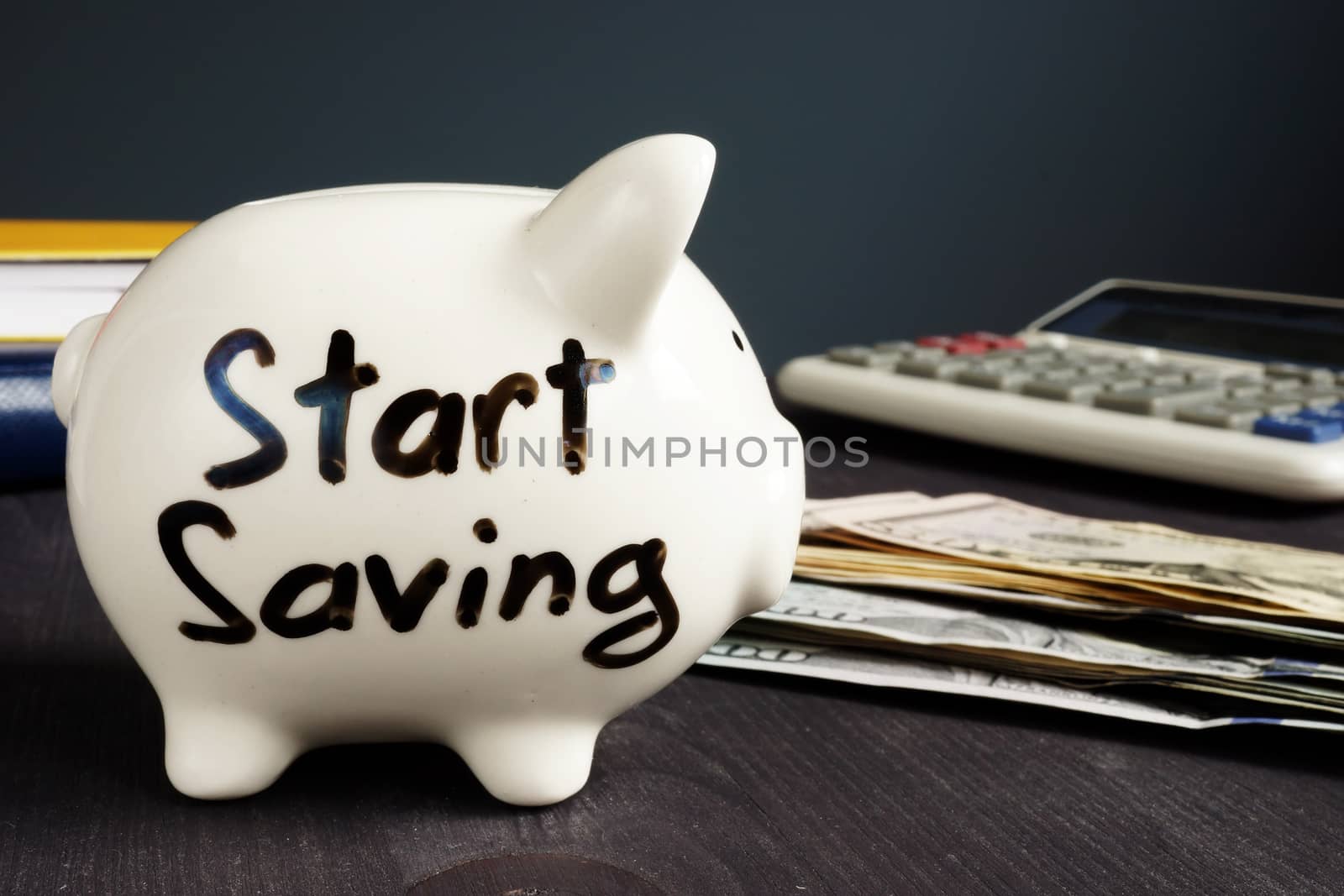 Start Saving written on a piggy bank and money.