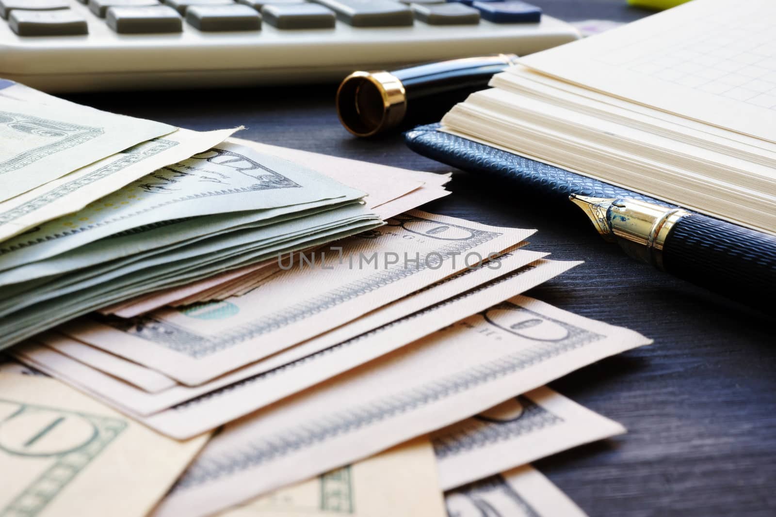 Personal finances. Dollar banknotes, notepad and calculator.