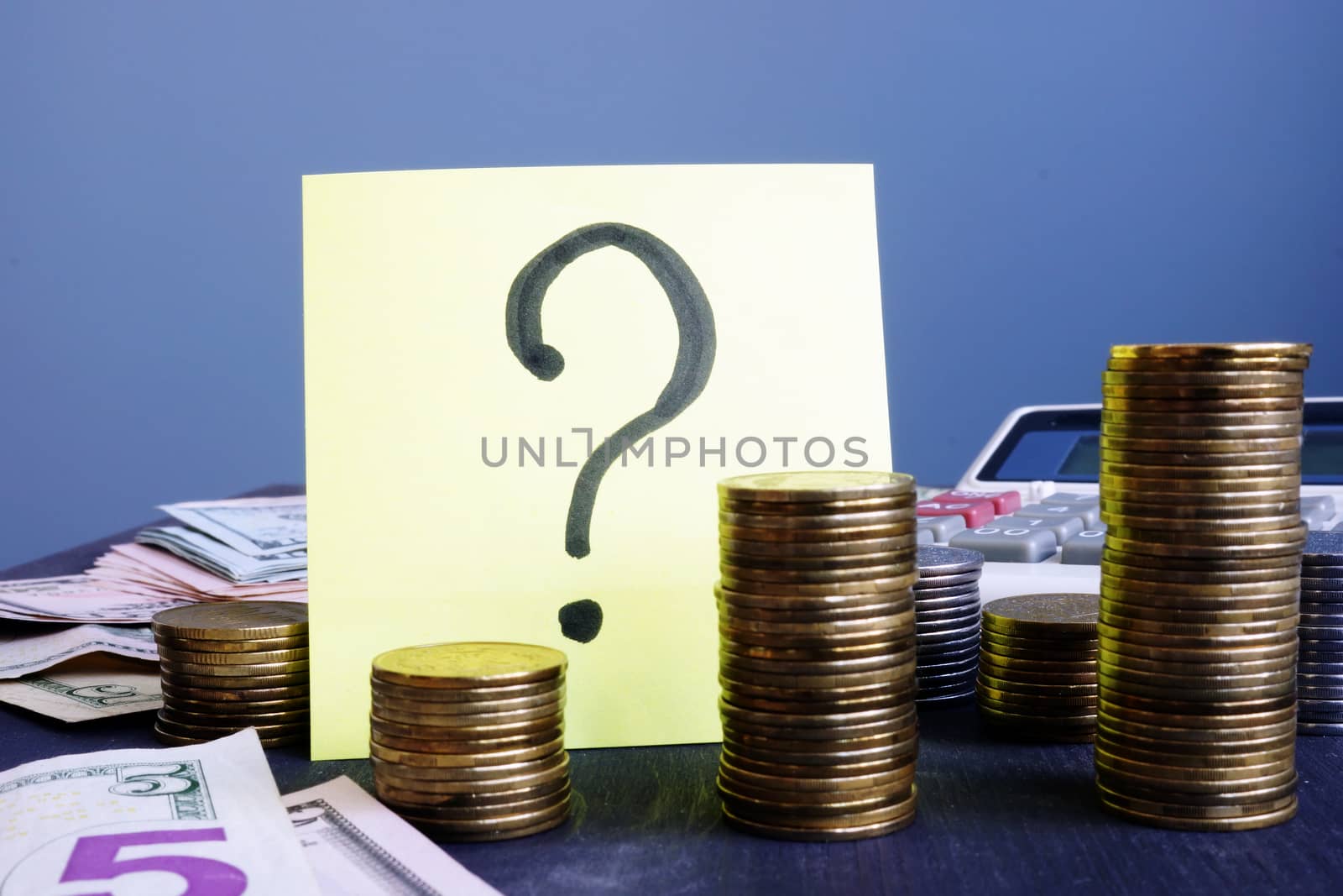Question mark and stacks of coins. Business uncertainty concept.