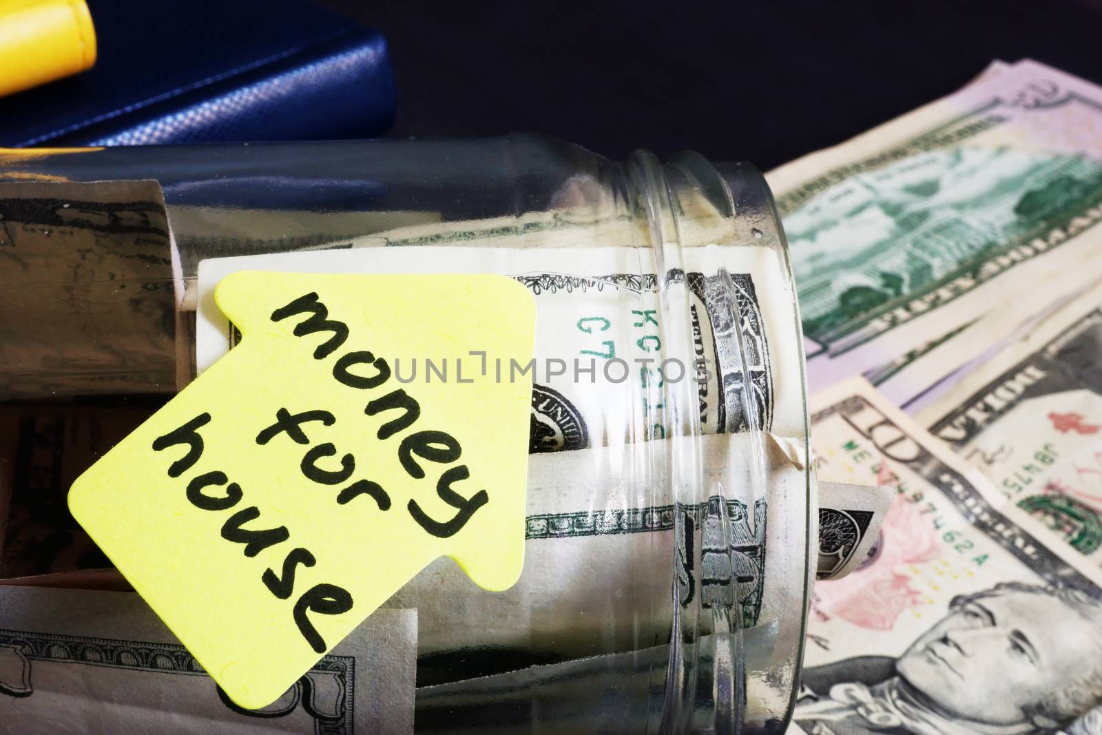 Money for house. Jar with dollars on a desk.