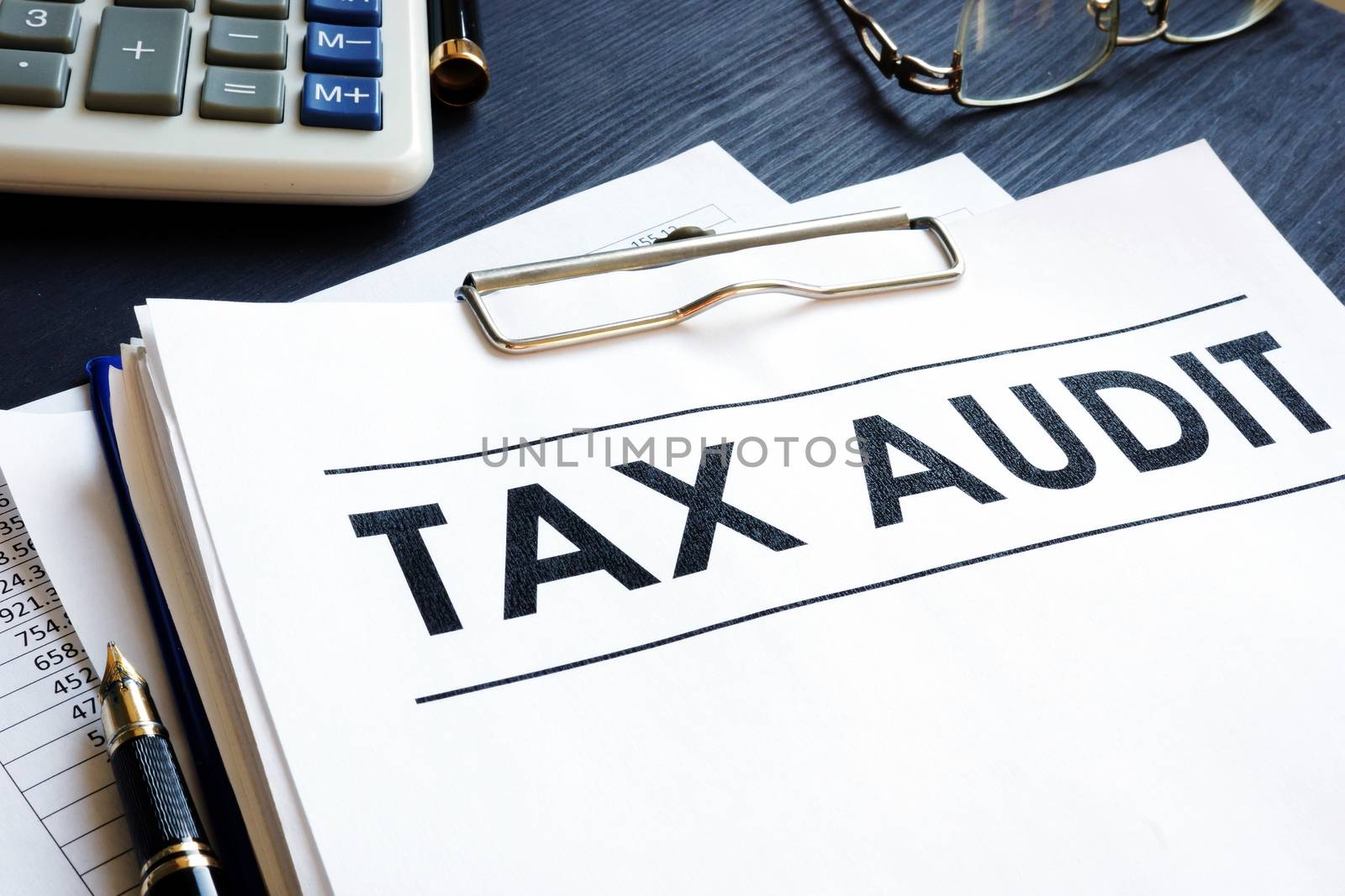 Tax audit documents and calculator on a table.