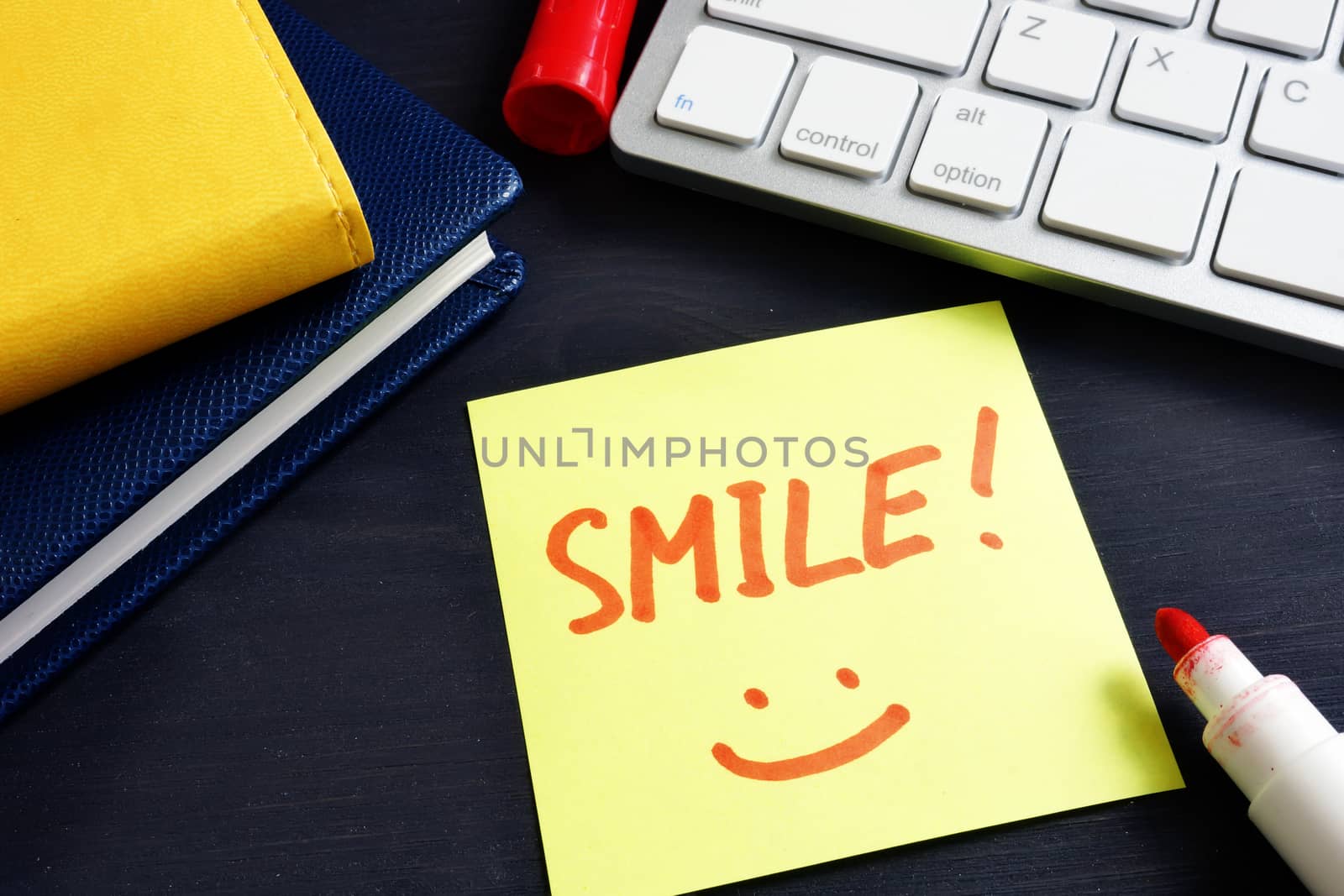 Memo stick with sign Smile in an office. Inspiration.