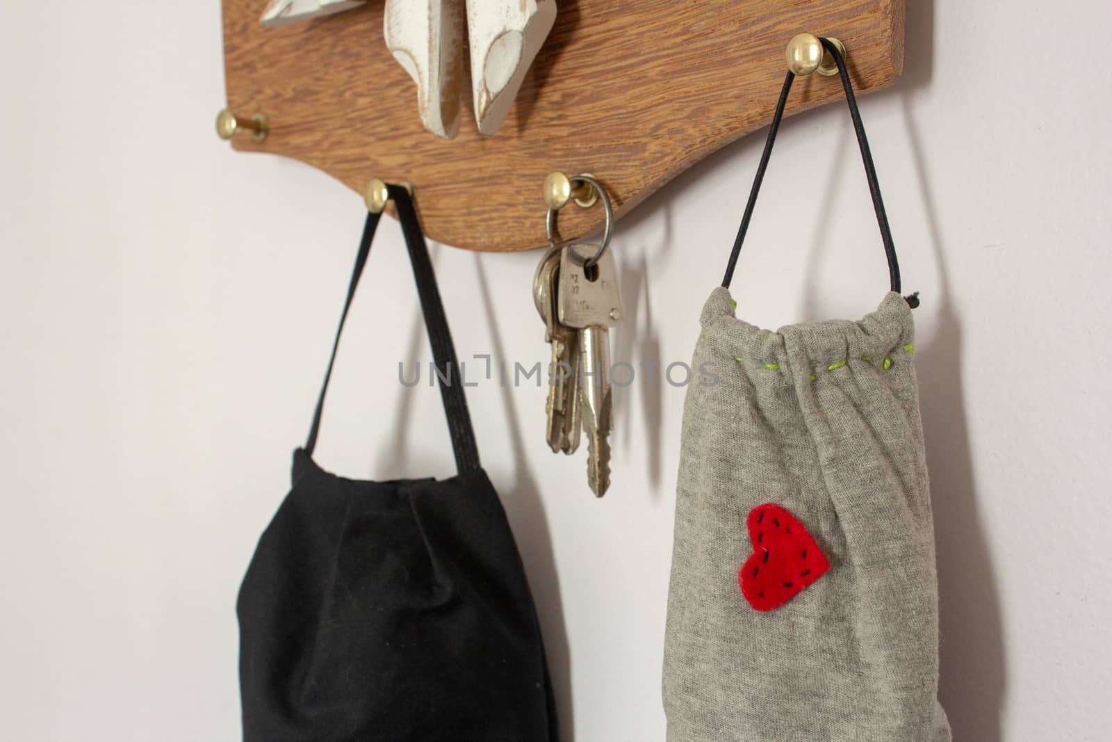 Masks hanging on the wall next to keys, as a new daily item to use because COVID-19