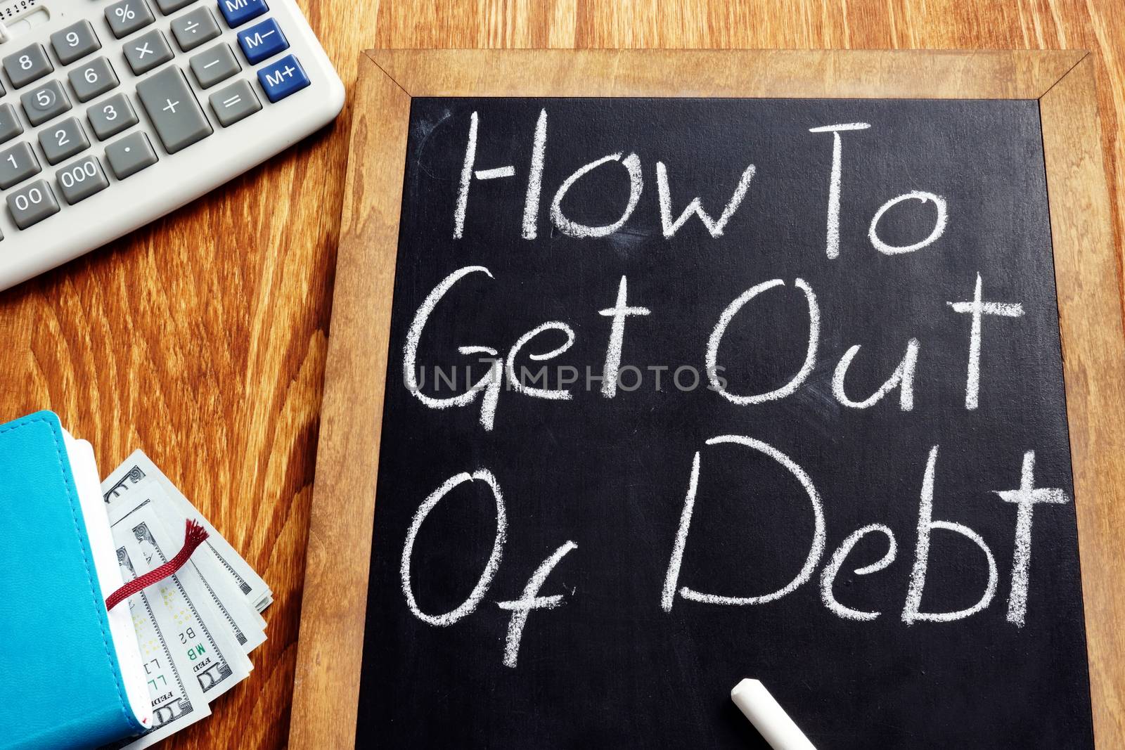 How to get out of debt handwritten on a blackboard.