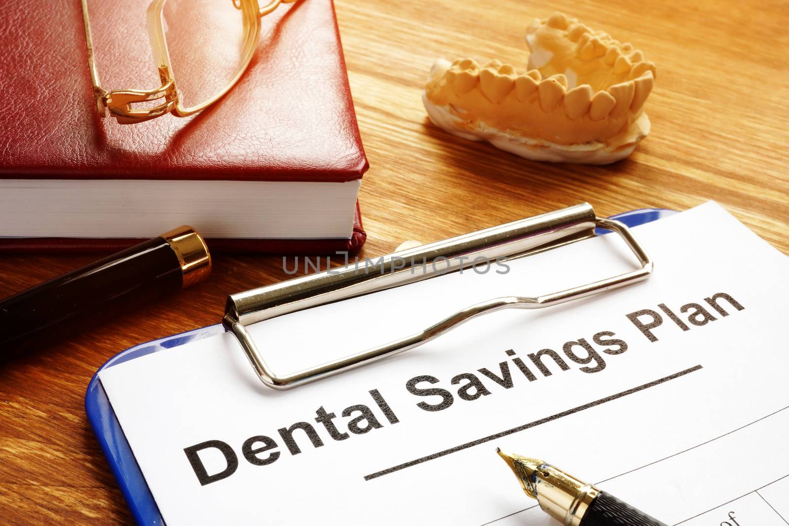 Dental Savings Plan with clipboard on desk. by designer491