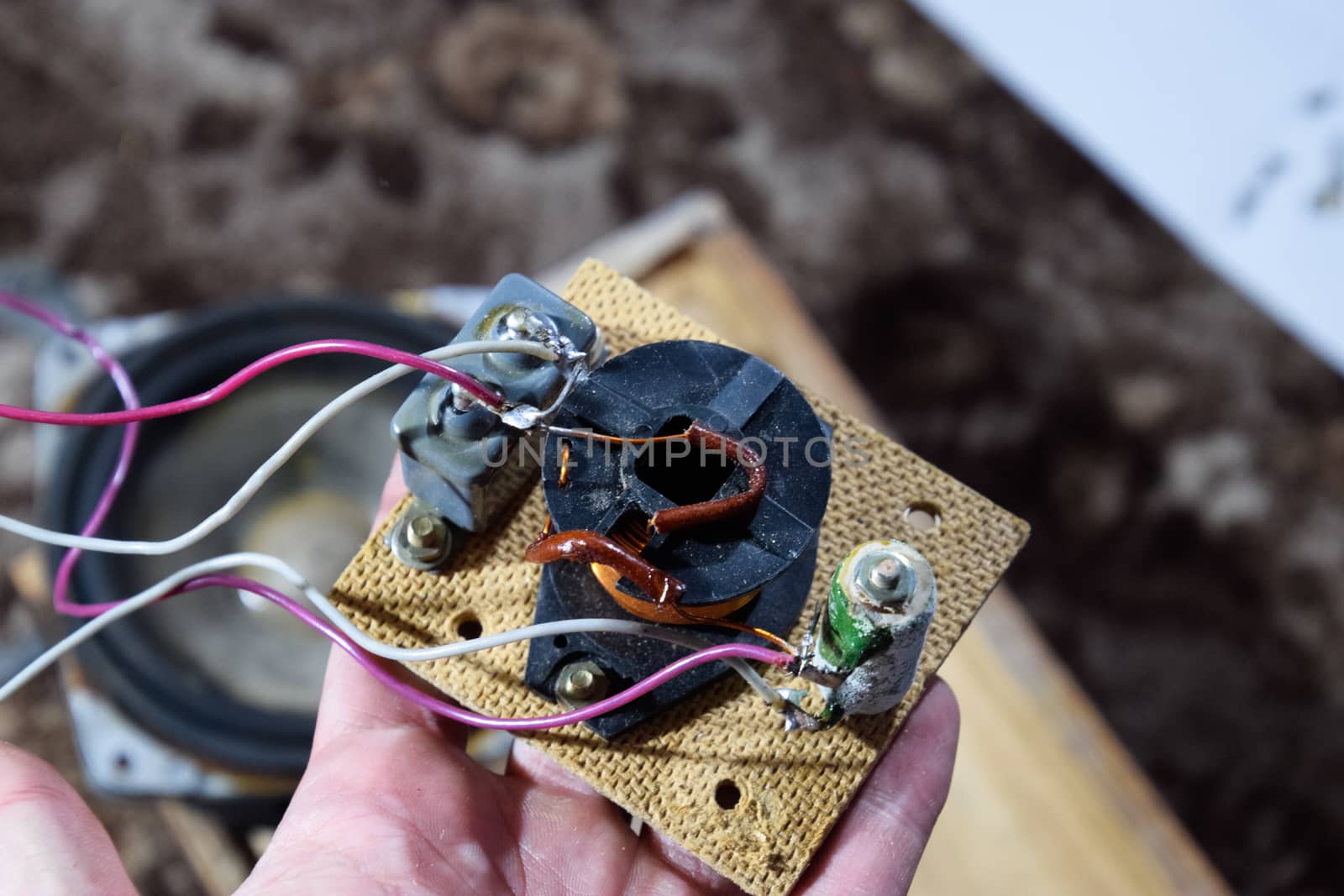 Acoustic filter in a music column. Electrical circuit of a magnetic coil, capacitor and resistance. Repair of acoustic dynamics, ration soldering wire on the speaker.