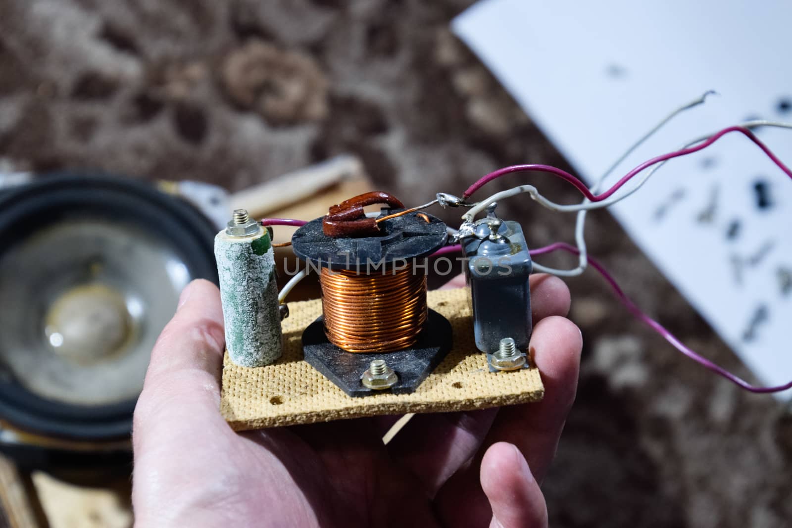 Acoustic filter in a music column. Electrical circuit of a magnetic coil, capacitor and resistance. Repair of acoustic dynamics, ration soldering wire on the speaker.