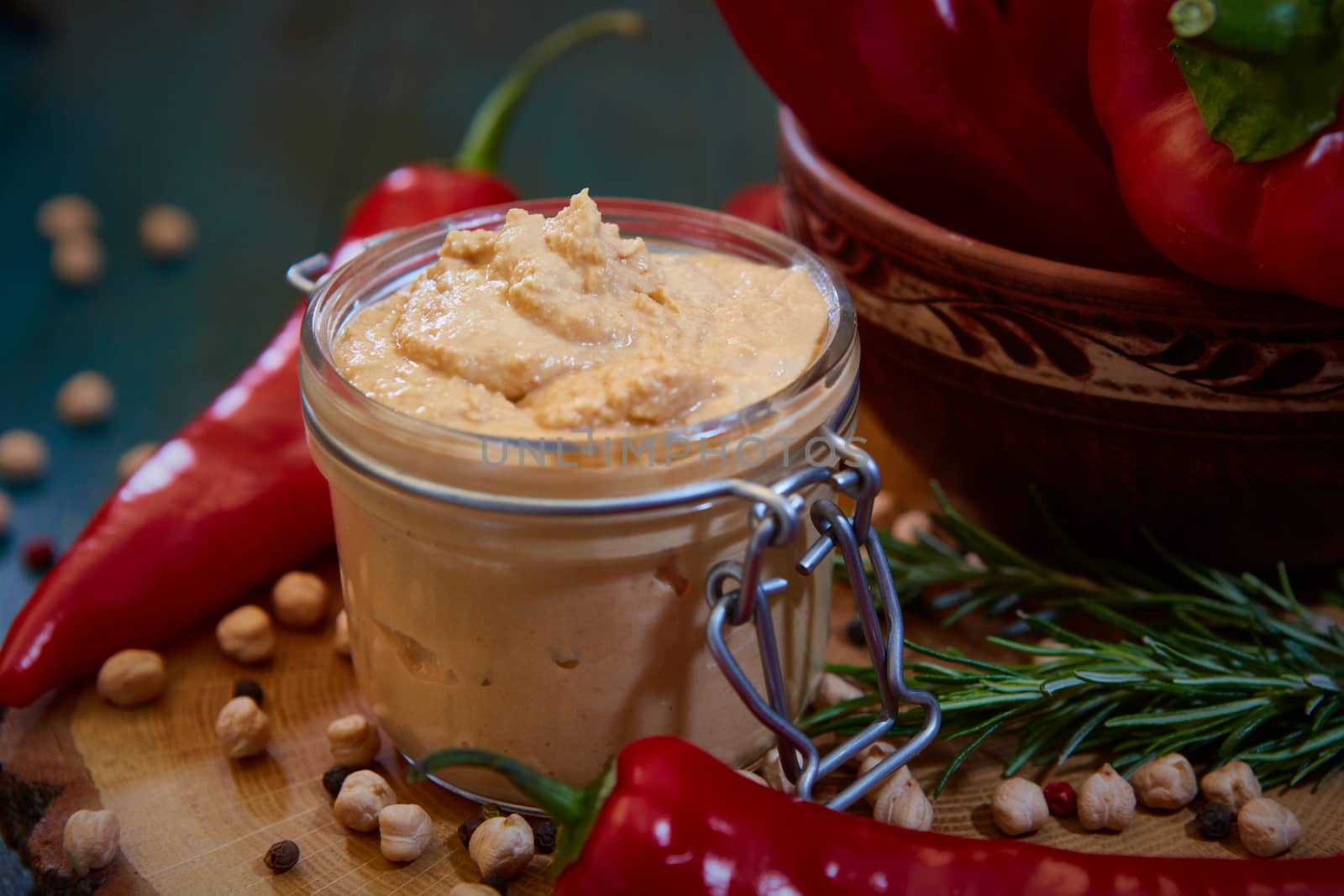 Homemade hummus with red pepper on a wood table. Selective focus and small depth of field.