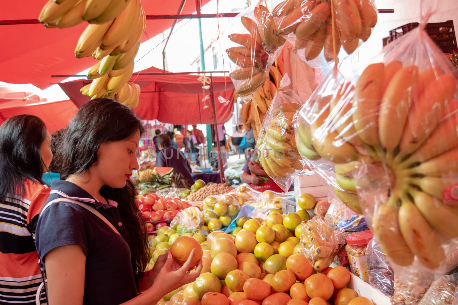 Woman buying some vegetables and fruits in a local mexican market