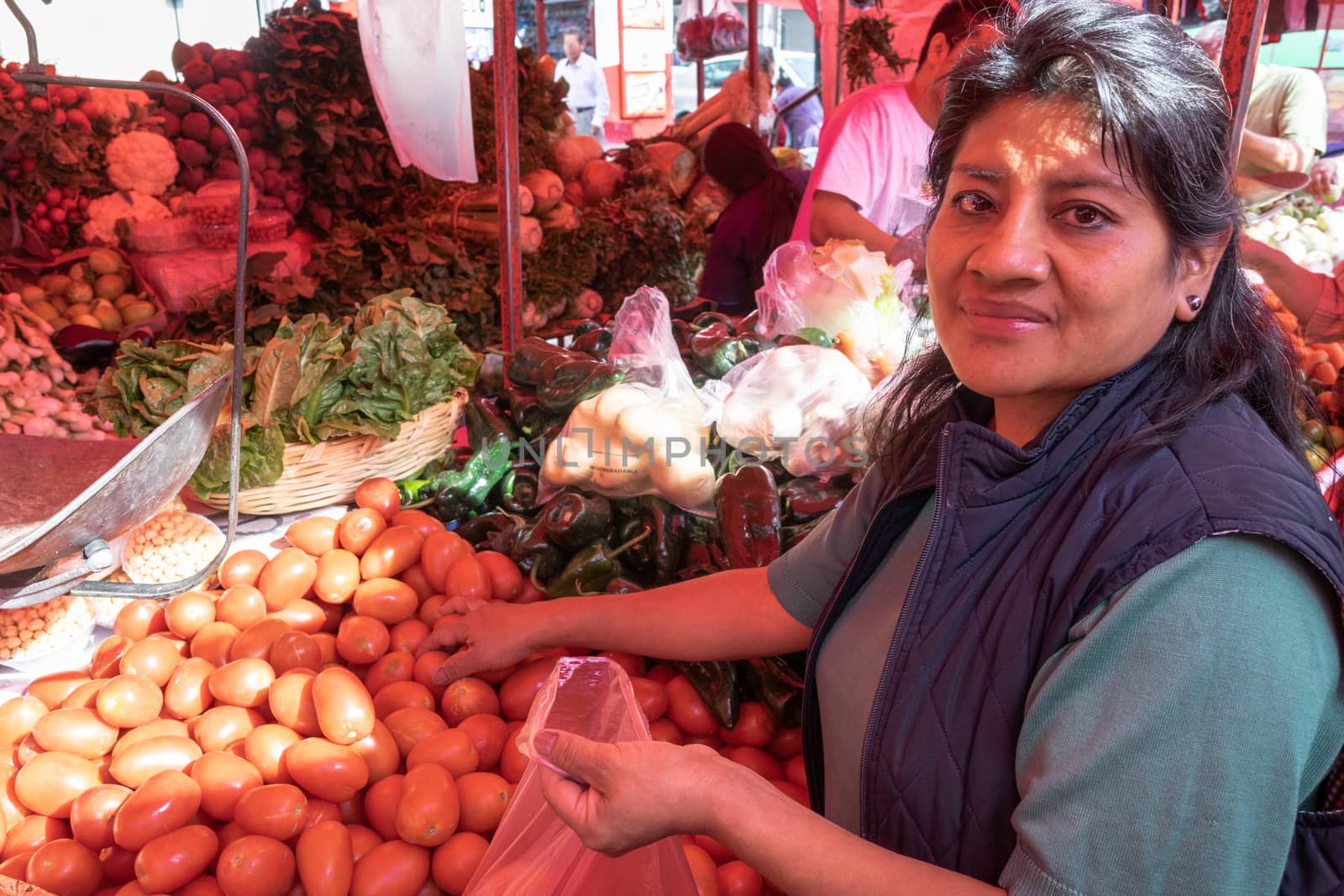 Woman buying some vegetables and fruits in a local mexican market