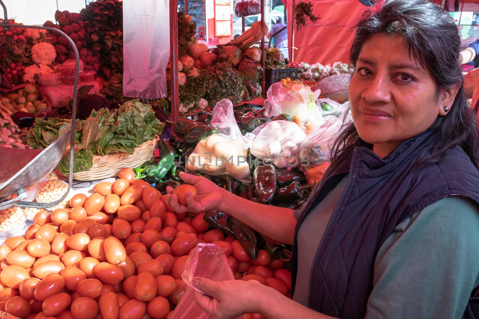 Woman buying some vegetables and fruits in a local mexican market