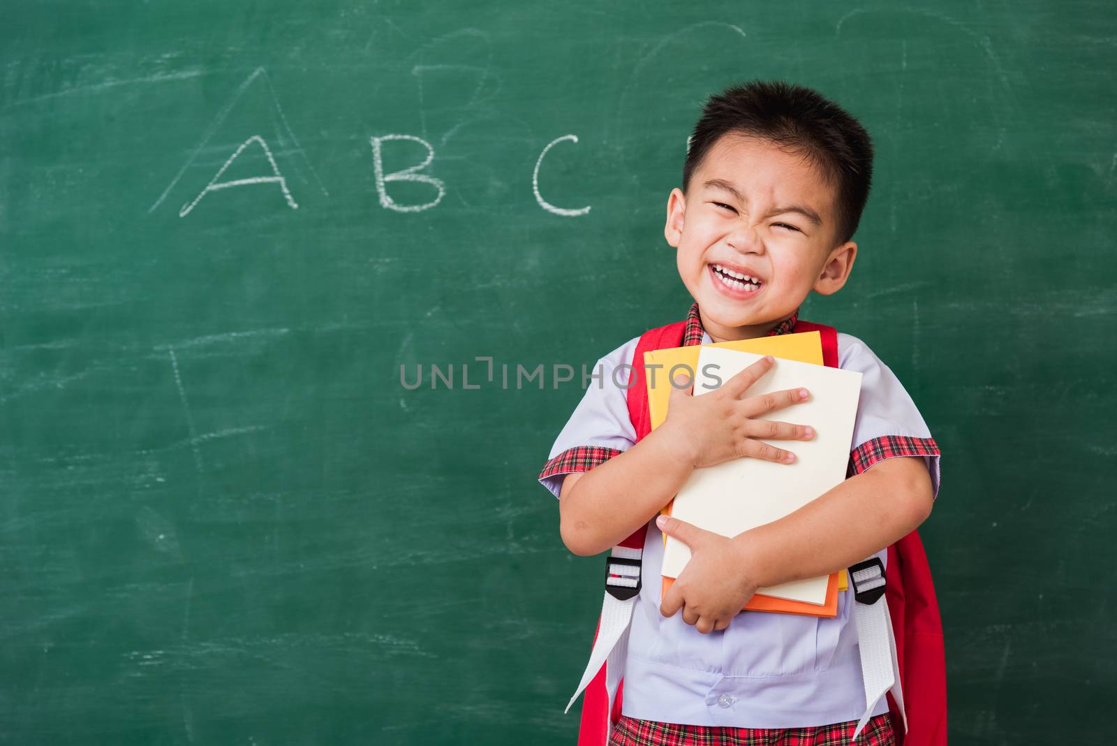 Child boy from kindergarten in student uniform with school bag a by Sorapop