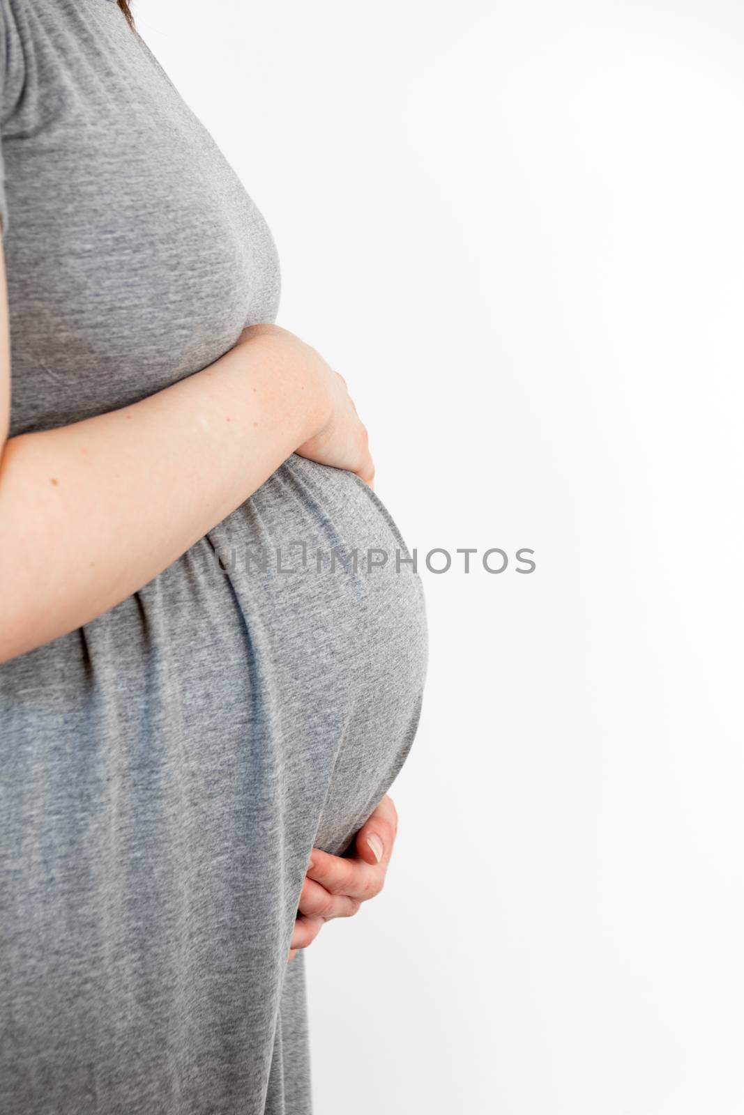 Pregnant woman caring and sharing love with her baby by touching her belly with hands