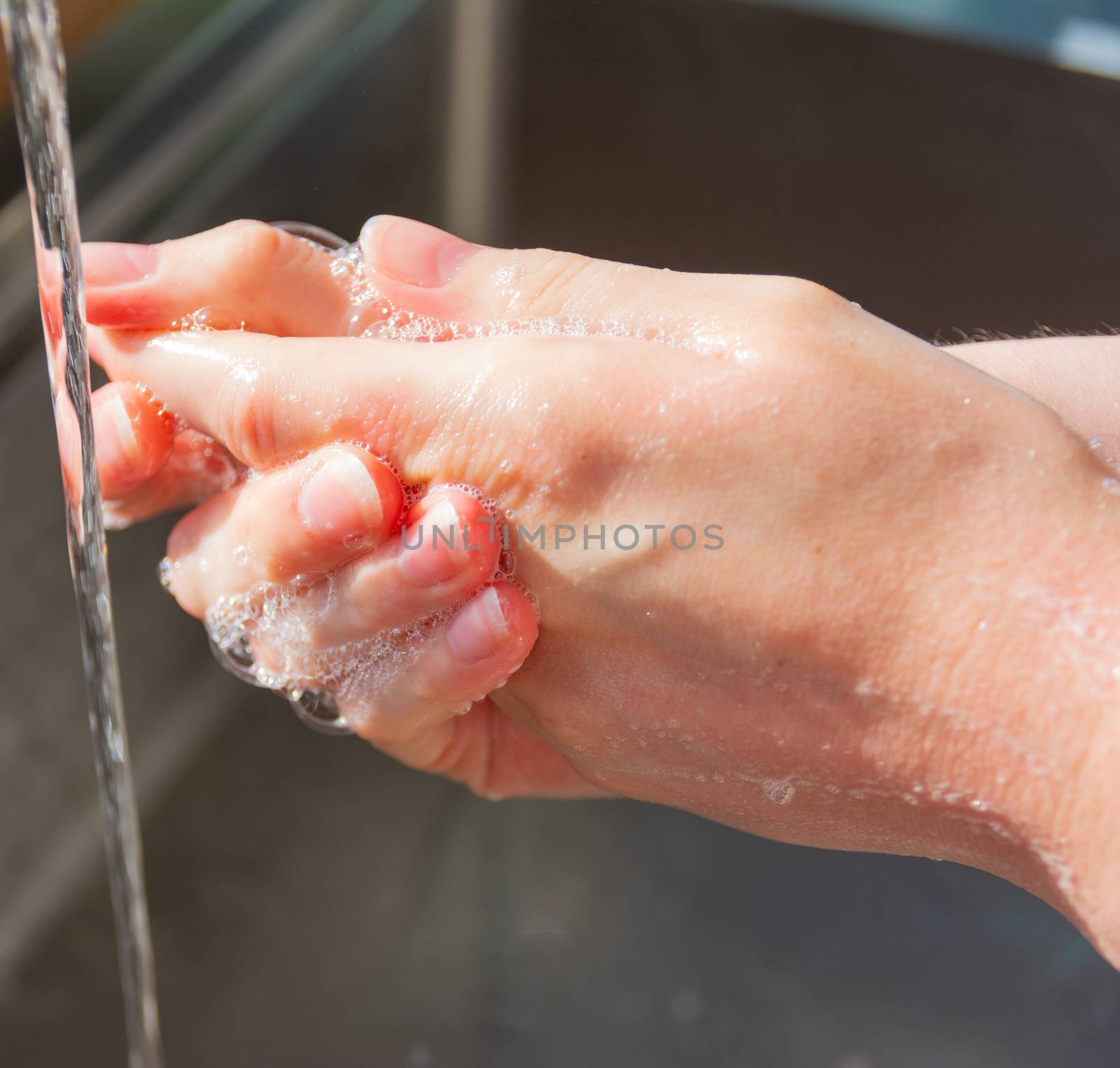 Woman washing hands with soap to prevent germs, bacteria and avoid coronavirus infections