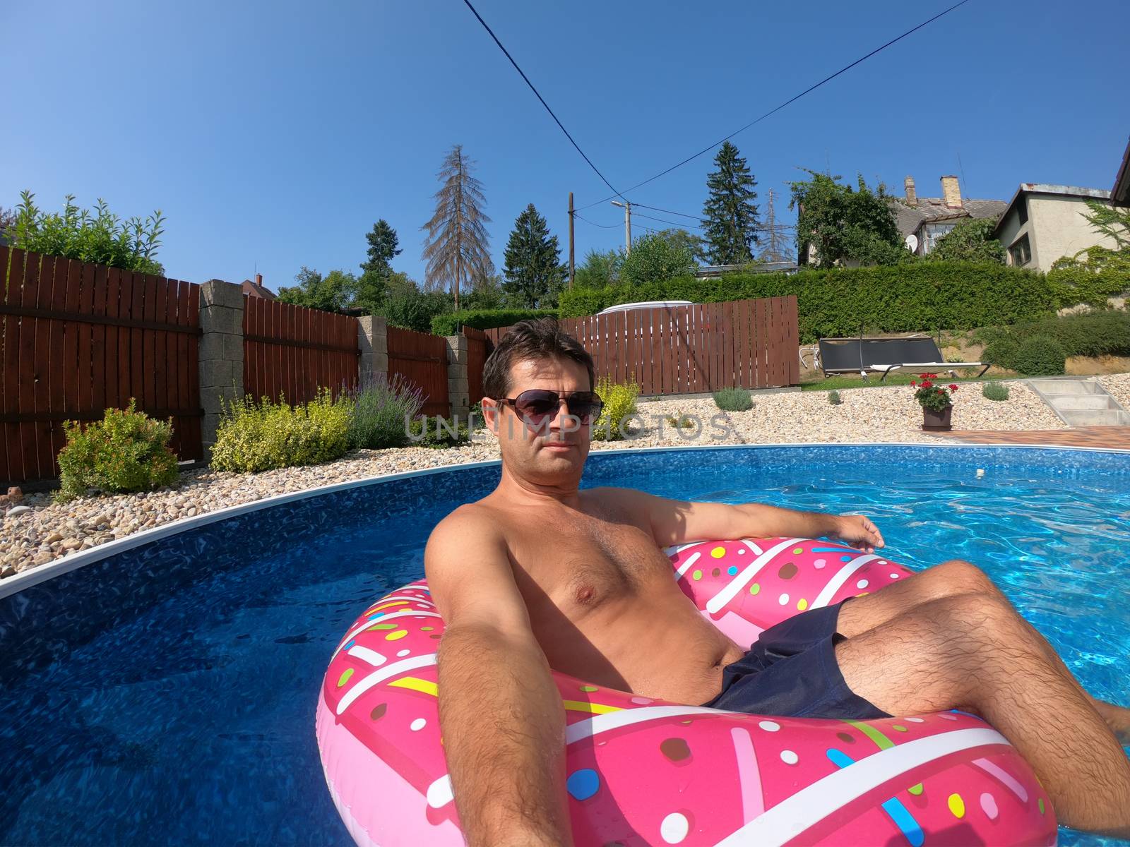 Happy man relax on inflatable ring. Holiday 2020 by artush