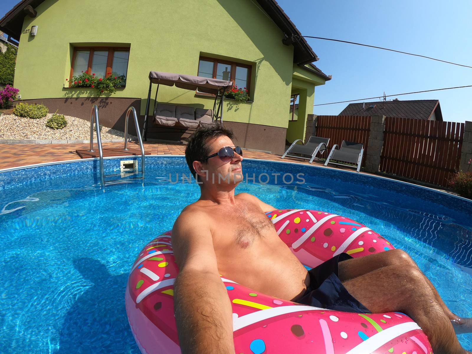 Happy man relax on inflatable ring. Holiday 2020 by artush