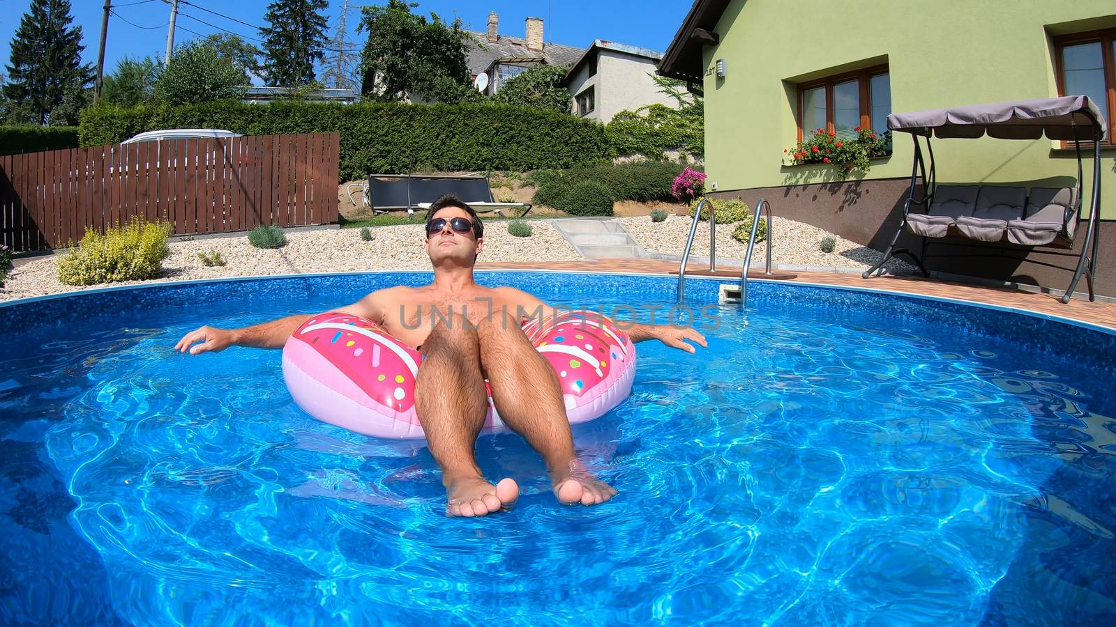 Happy man relax on inflatable ring. Holiday 2020 by artush