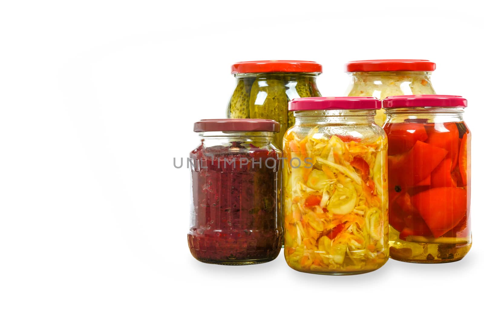 Jars with variety of homemade pickled vegetables isolated on a white background with copy space place .