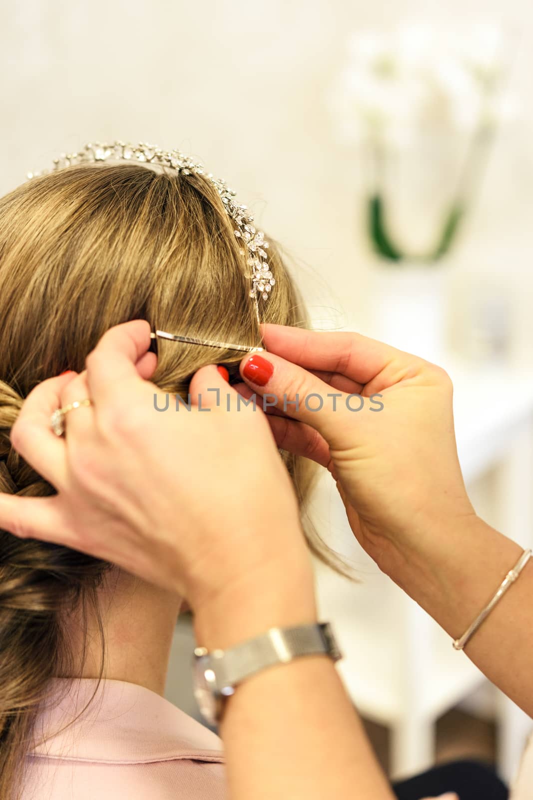 Professional services in the hairdressing salon  - a young woman with beautiful blonde hair has made hairstyles for a wedding party.