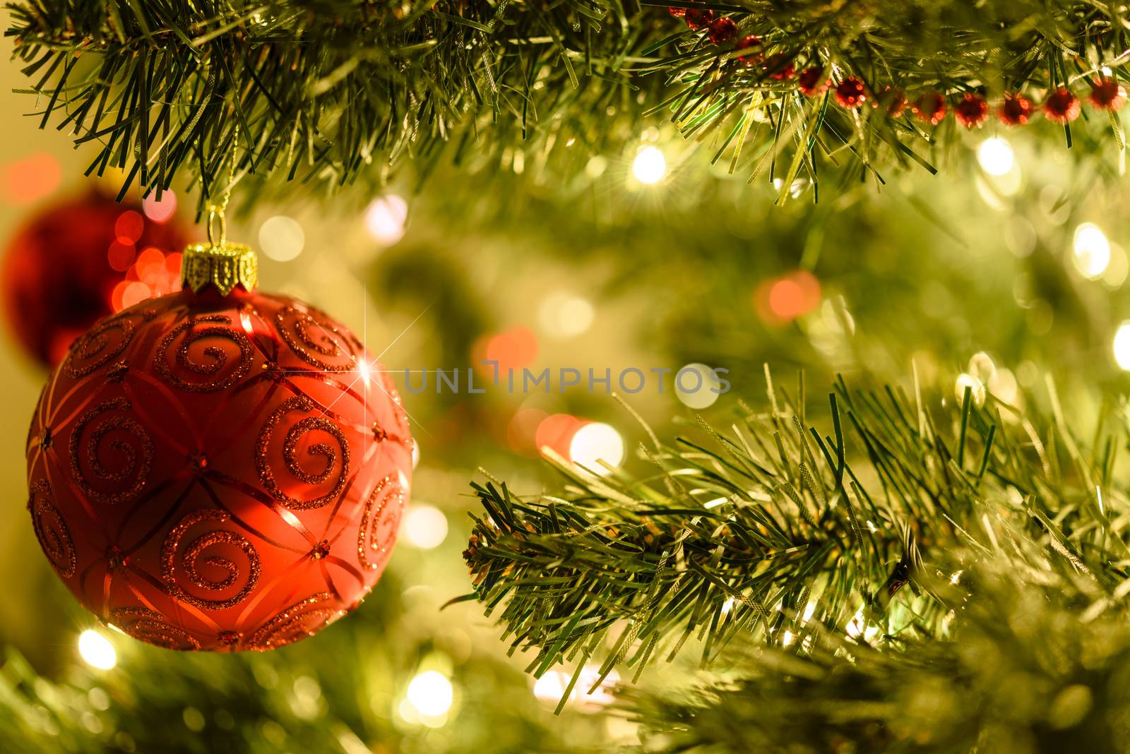 Beautiful Christmas background - red baubles on a background of blurred lights on a Christmas tree with bokeh effect.