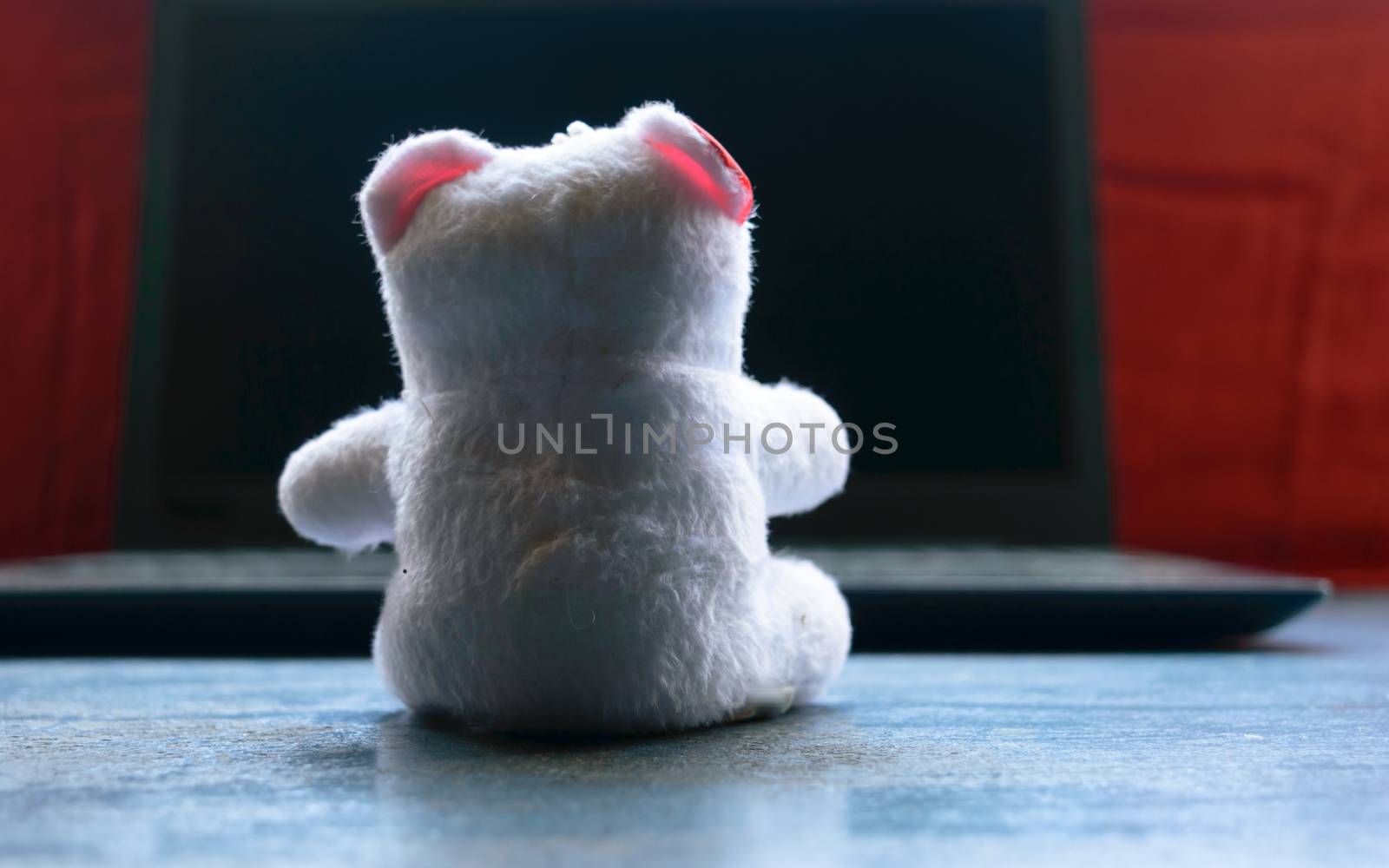 Teddy bear sitting in front of laptop computer device. Still Life. Child using digital technology. Conceptual background concept. Modern childhood education theme. Copy space room for text for massage.