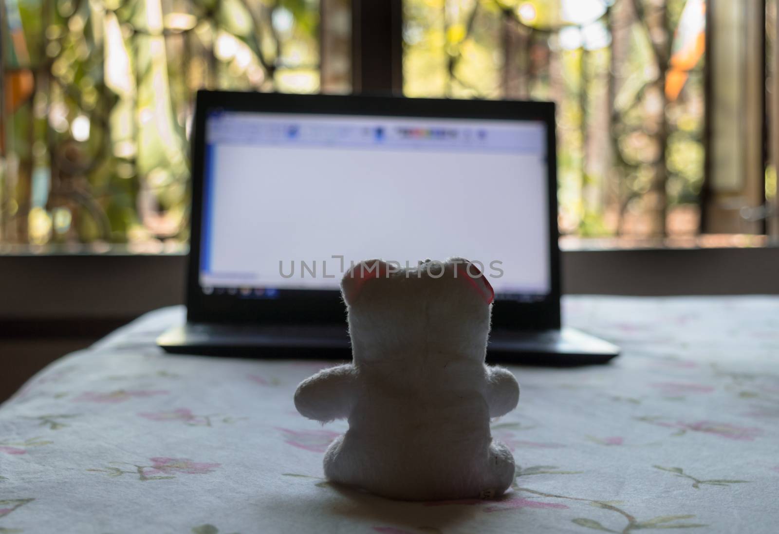 Teddy bear sitting in front of laptop computer device. Still Life. Child using digital technology. Conceptual background concept. Modern childhood education theme. Copy space room for text for massage.