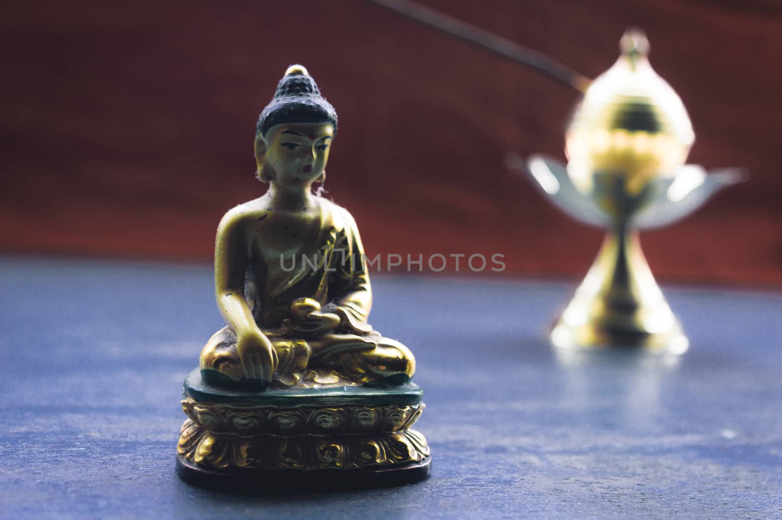 Close up Still Life of antique Meditating Buddha and bell on rustic floor. Faith, Tradition, Spirituality, Prayer, symbols of peace and Religious Themes. Arts and culture background concept. Copy space room for text for massage.