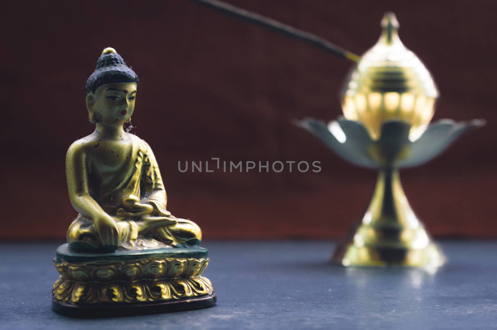 Close up Still Life of antique Meditating Buddha and bell on rustic floor. Faith, Tradition, Spirituality, Prayer, symbols of peace and Religious Themes. Arts and culture background concept. Copy space room for text for massage. by sudiptabhowmick