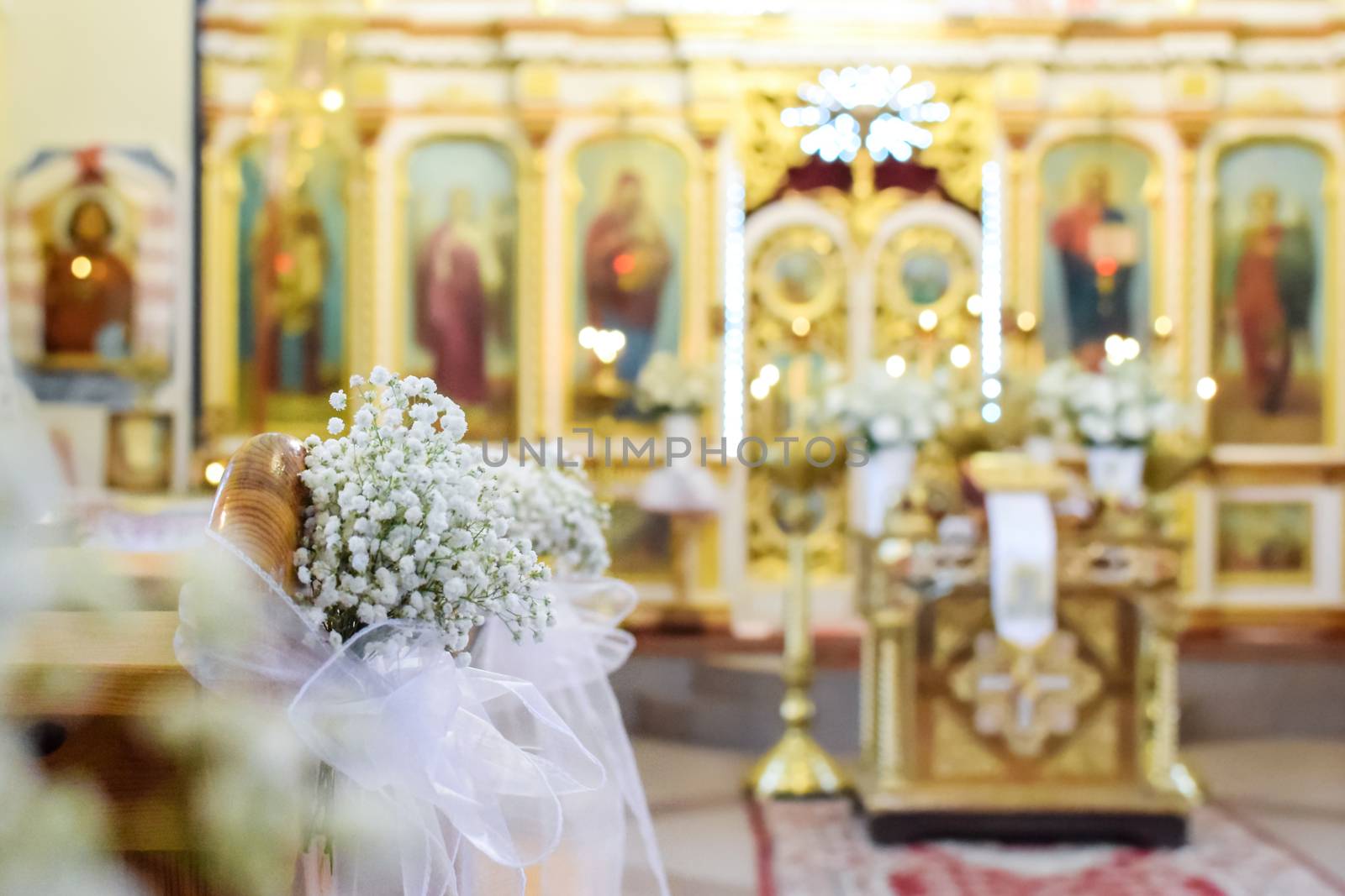 Decoration of wedding flowers against the background of a beautifully blurred orthodox church interior 