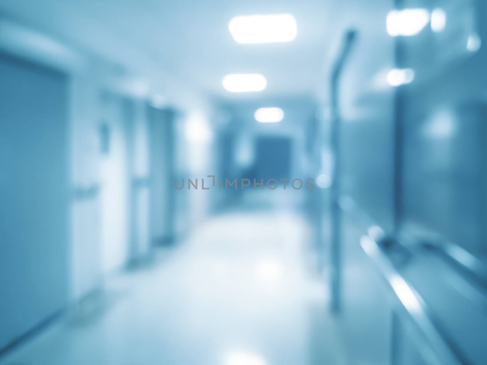 Blurred abstract hospital background - corridor with rooms for patients and bokeh lights (blue filter effect).
