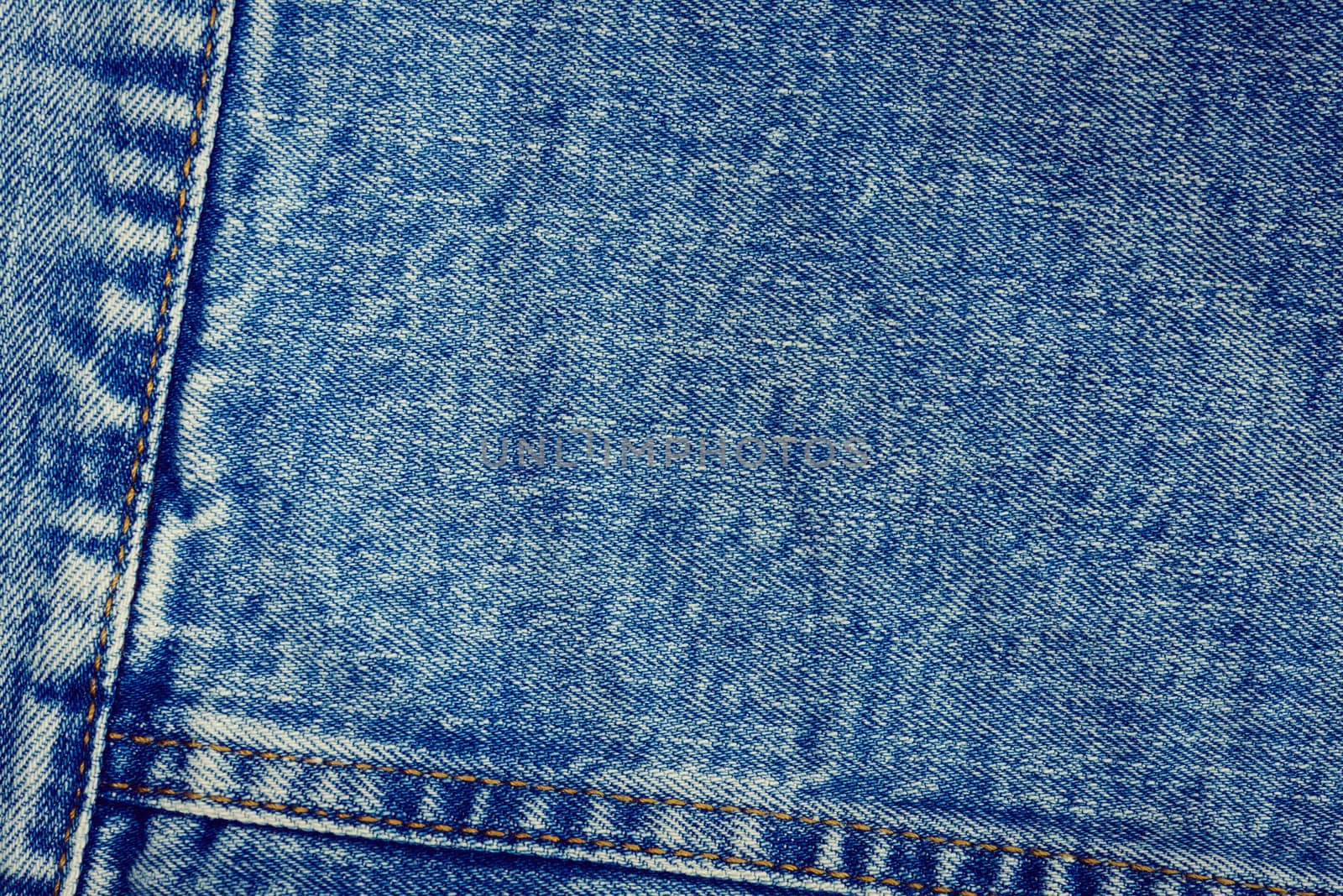 Textured vintage background - blue jeans textile denim with seam of fashion design in close-up (high details).