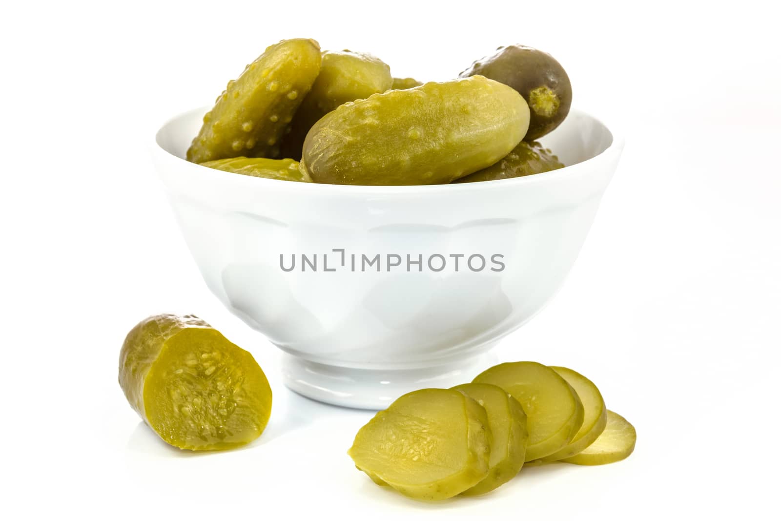 Bowl with pickled cucumbers on a white background in close-up