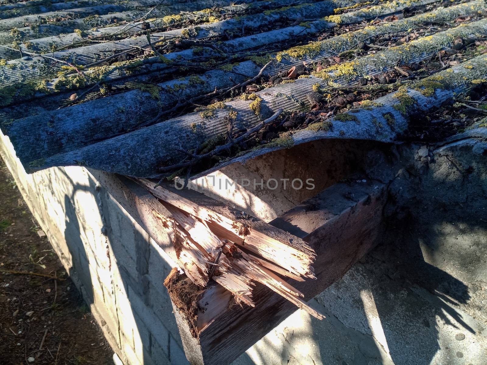 Broken roof of the barn. Broken slate and broken rafters.