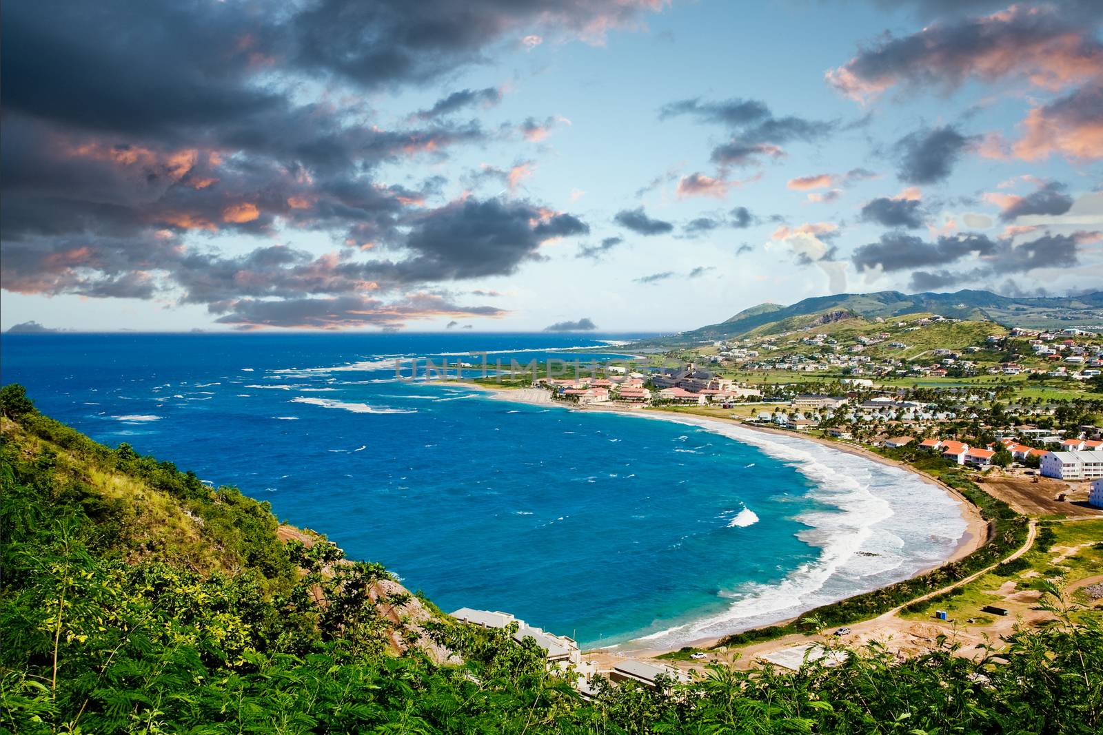 Deep Blue Sea and Green Hills under Blue Sky and Clouds