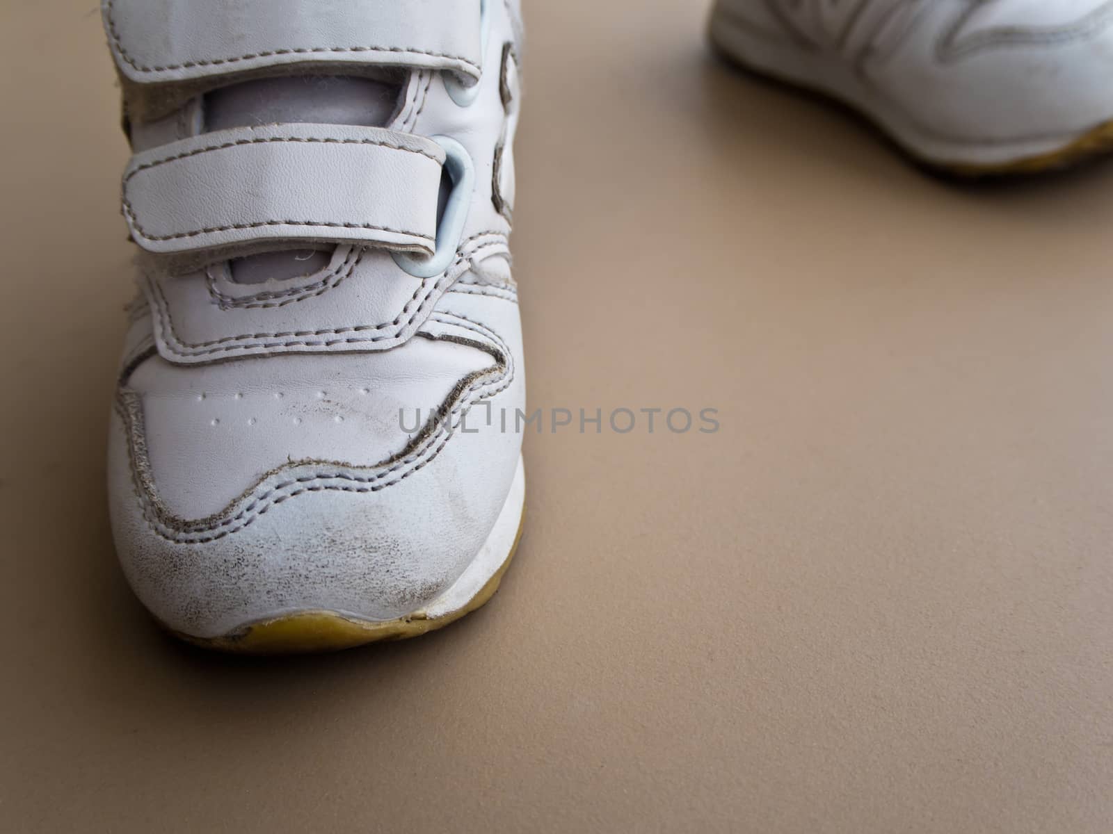 Closeup of children foot walking in sport shoes by Satakorn