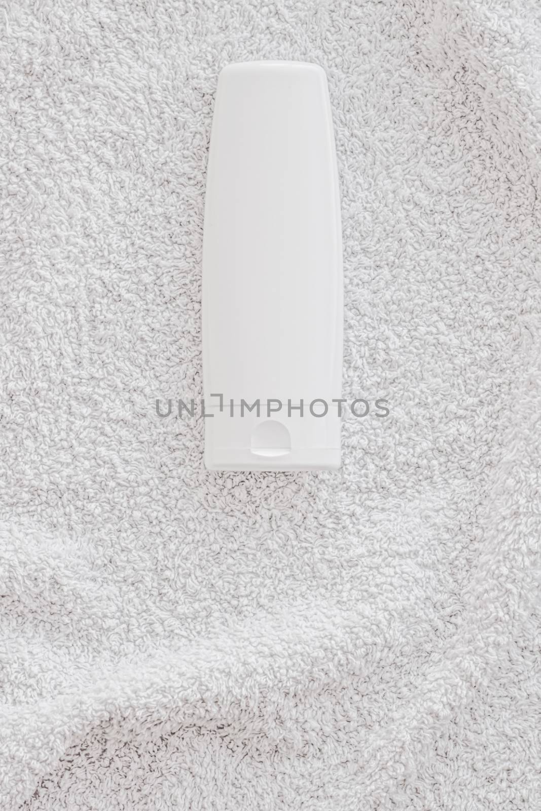 Blank label cosmetic container bottle as product mockup on white towel background by Anneleven