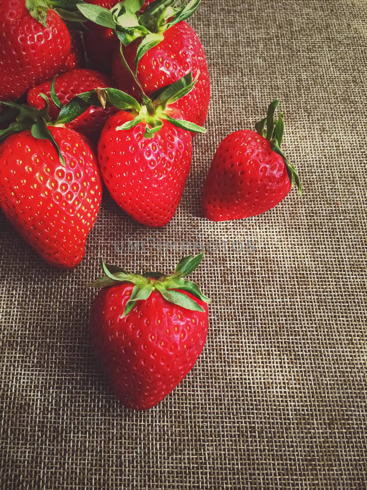 Organic strawberries on rustic linen background by Anneleven