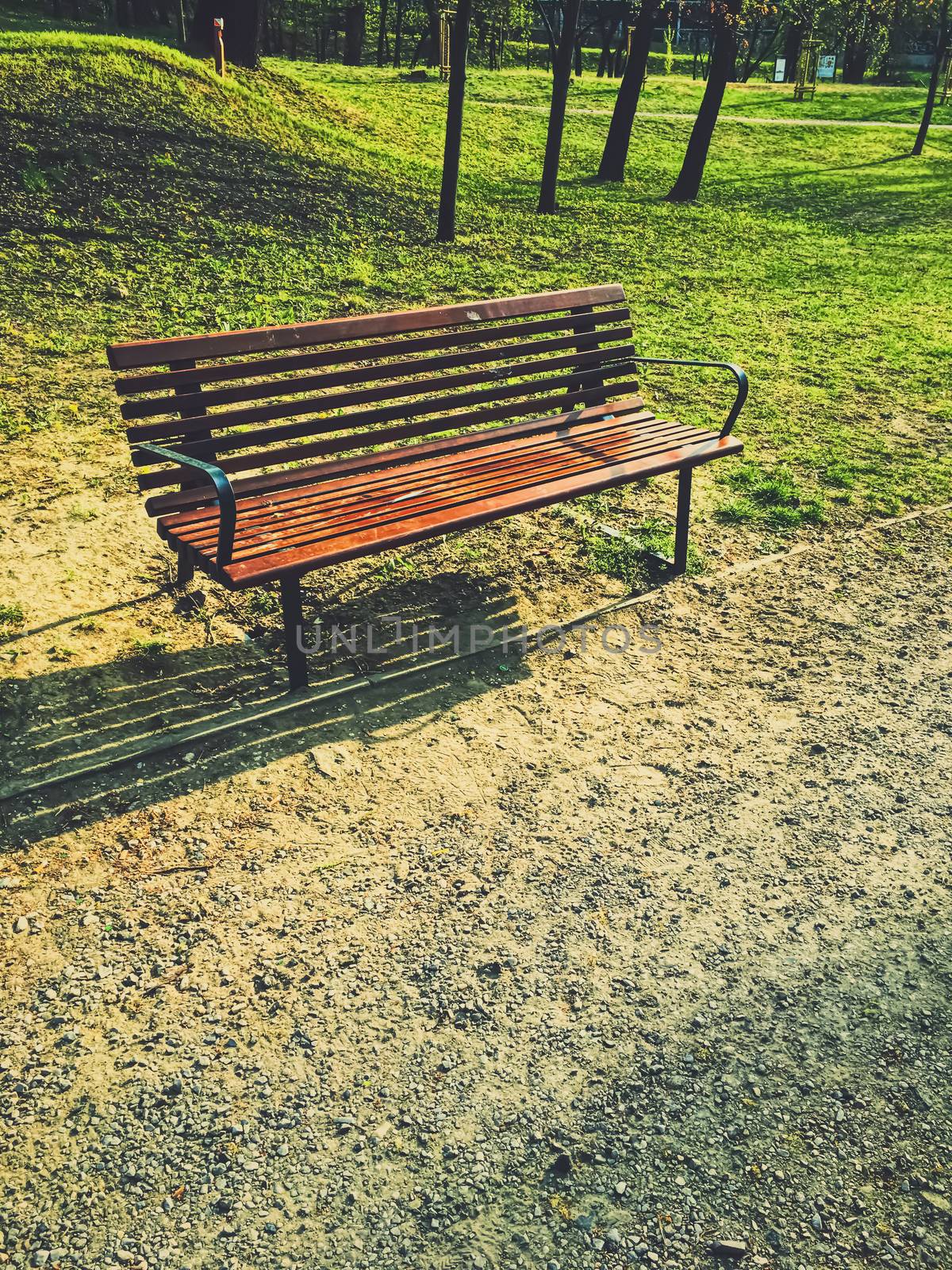 Empty bench in park during a city lockdown in coronavirus pandemic by Anneleven