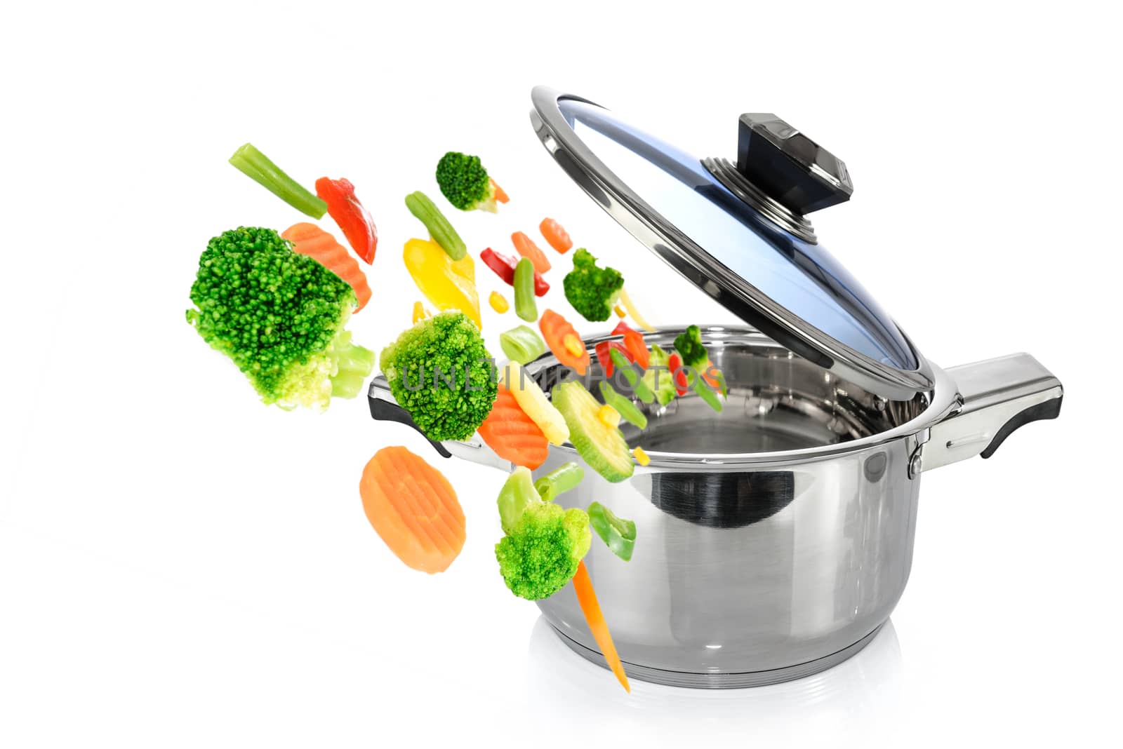 Healthy cooking concept image - mix vegetables falls into a stainless steel pot isolated on a white background.