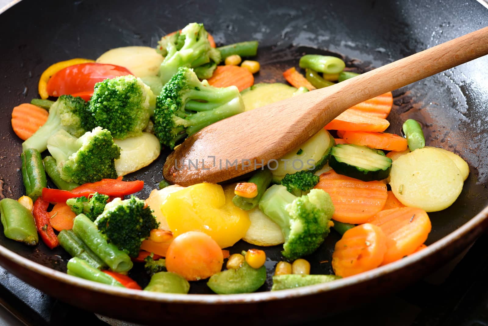 Mix of fresh vegetables fried in the pan in close-up.