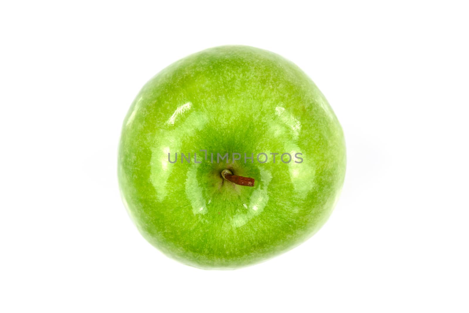 Top view of a shiny and fresh green apple in close-up and isolated on a white background.