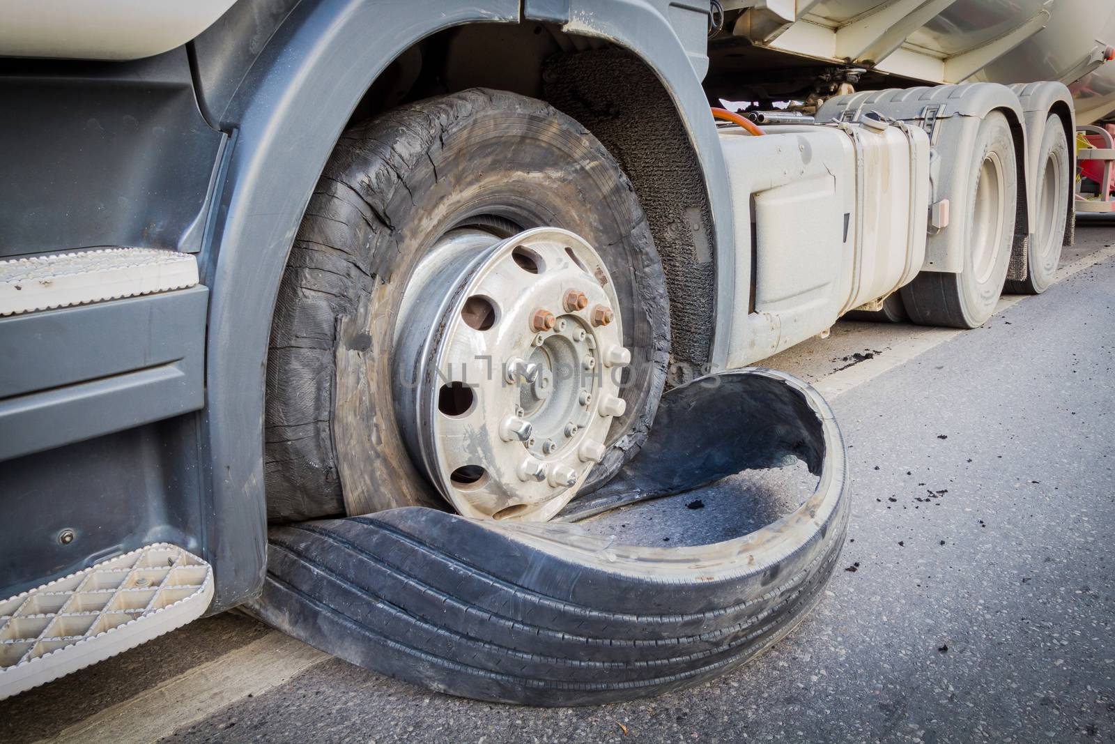 closeup damaged 18 wheeler semi truck burst tires by highway street